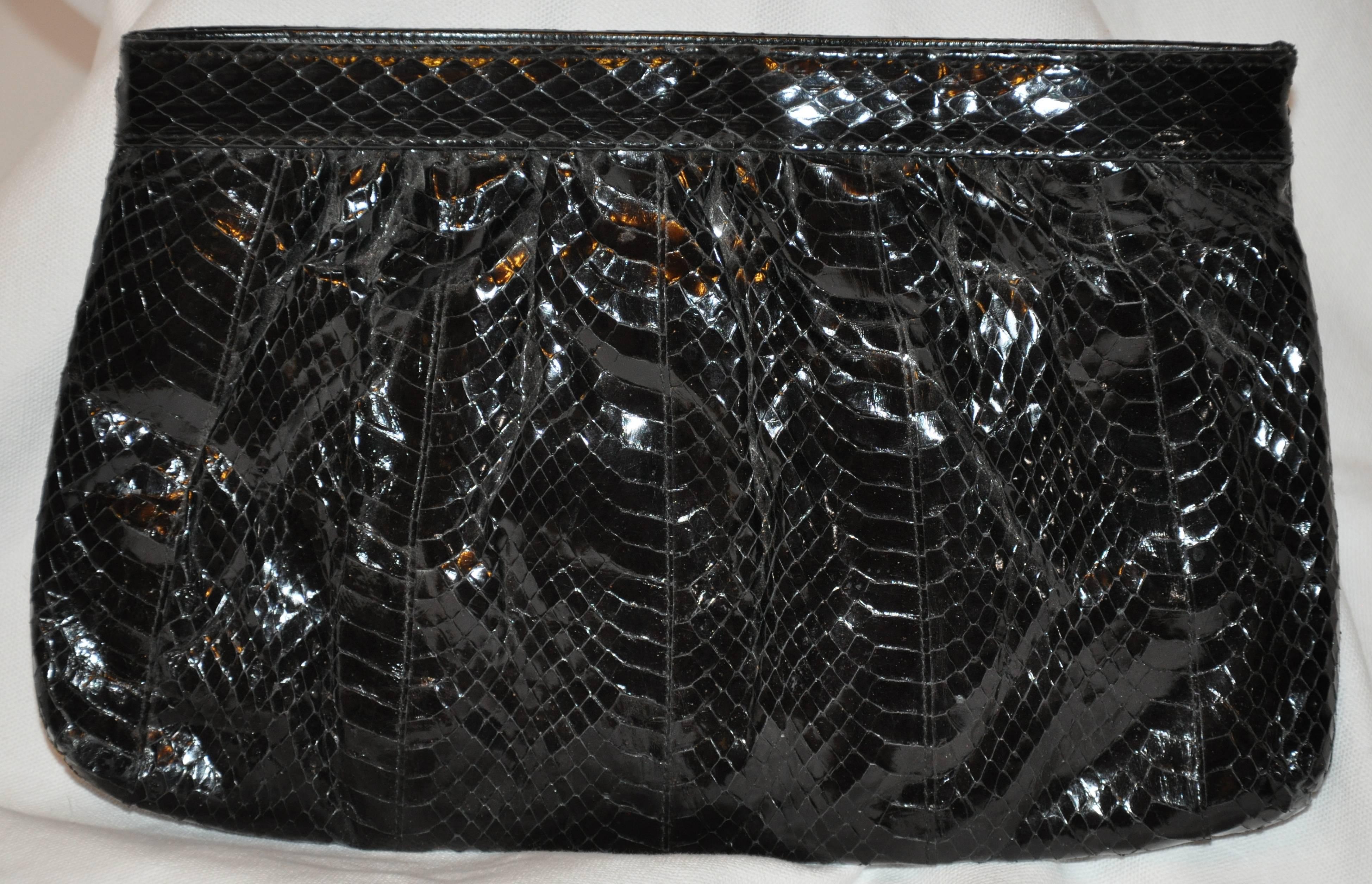        Saks Fifth Avenue elegant polished black snake clutch with optional shoulder straps features a "spring-back" opening as well as a zippered top. The optional calf-skin shoulder strap measures 44 inches in length. The interior has a