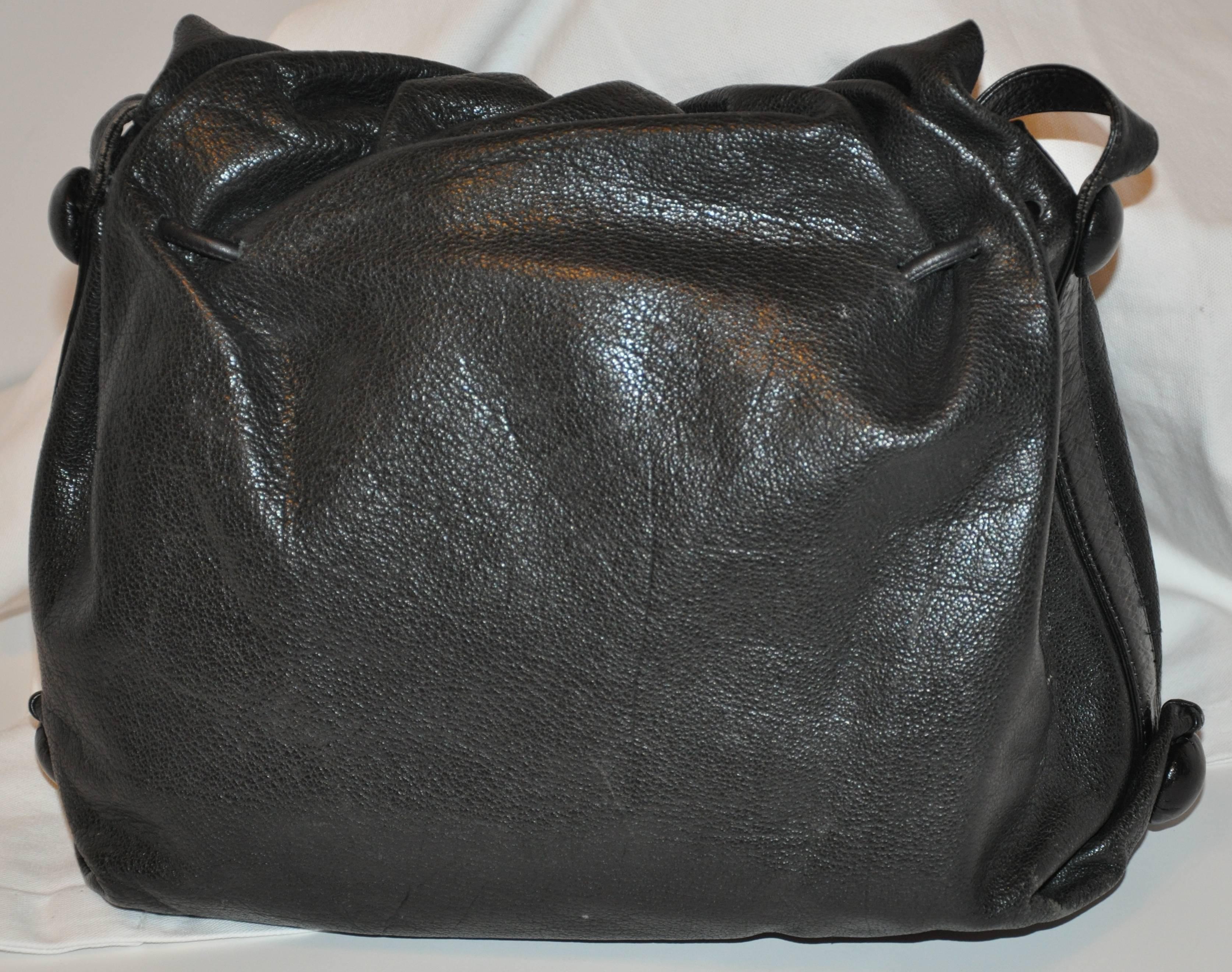        Le merveilleux sac à bandoulière en peau de buffle noir texturé signé Carlos Falchi est orné de ses célèbres patchs gravés à la main sur le rabat avant. Le rabat avant mesure 11 pouces de long. Les bretelles mesurent 1 pouce de largeur et ont