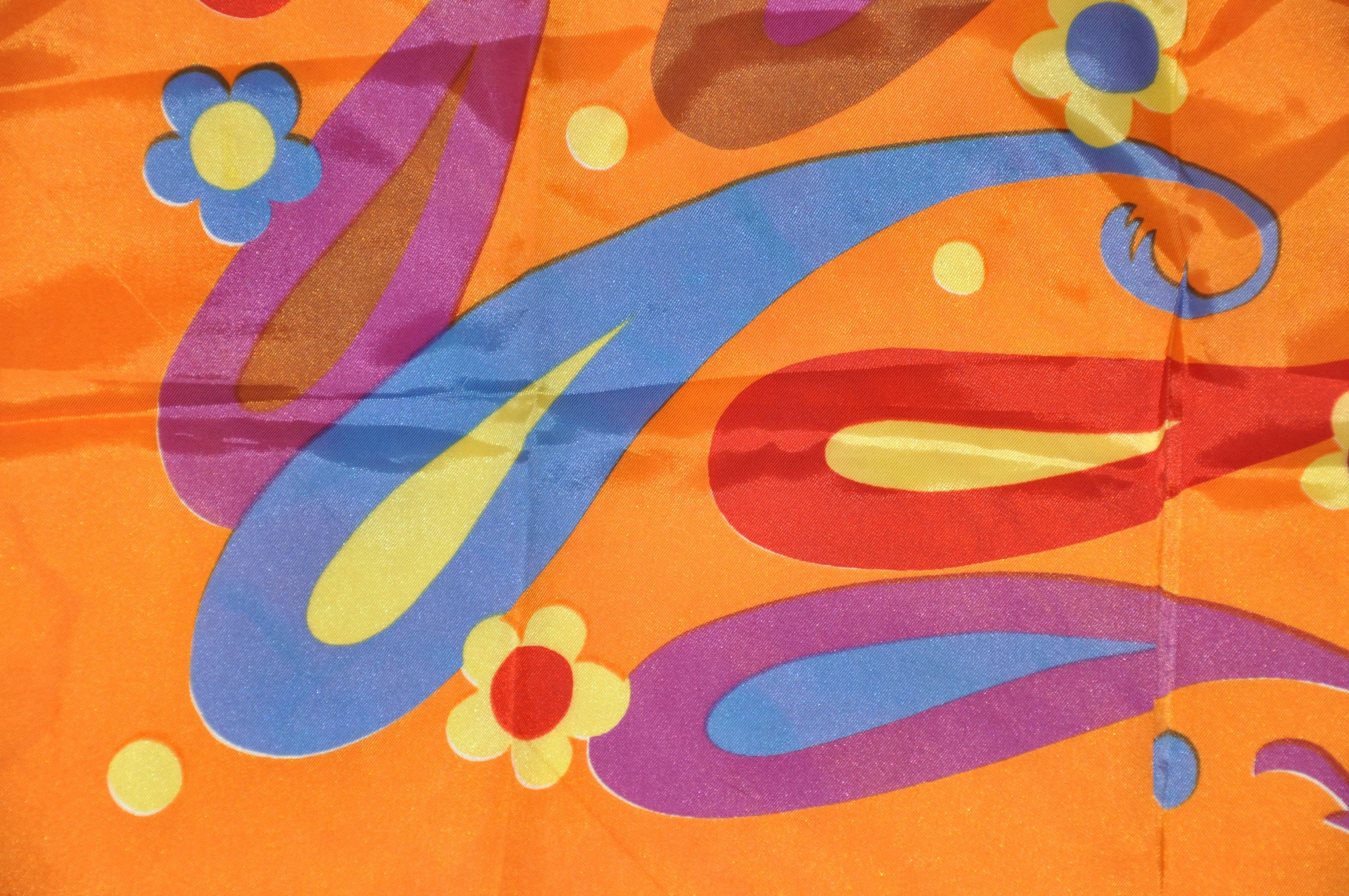        Ce magnifique foulard audacieux de couleur mandarine avec palsey multicolore en mélange d'acétate, accentué par des bords roulés, mesure 26 pouces par 26 pouces. Fabriqué au Japon.