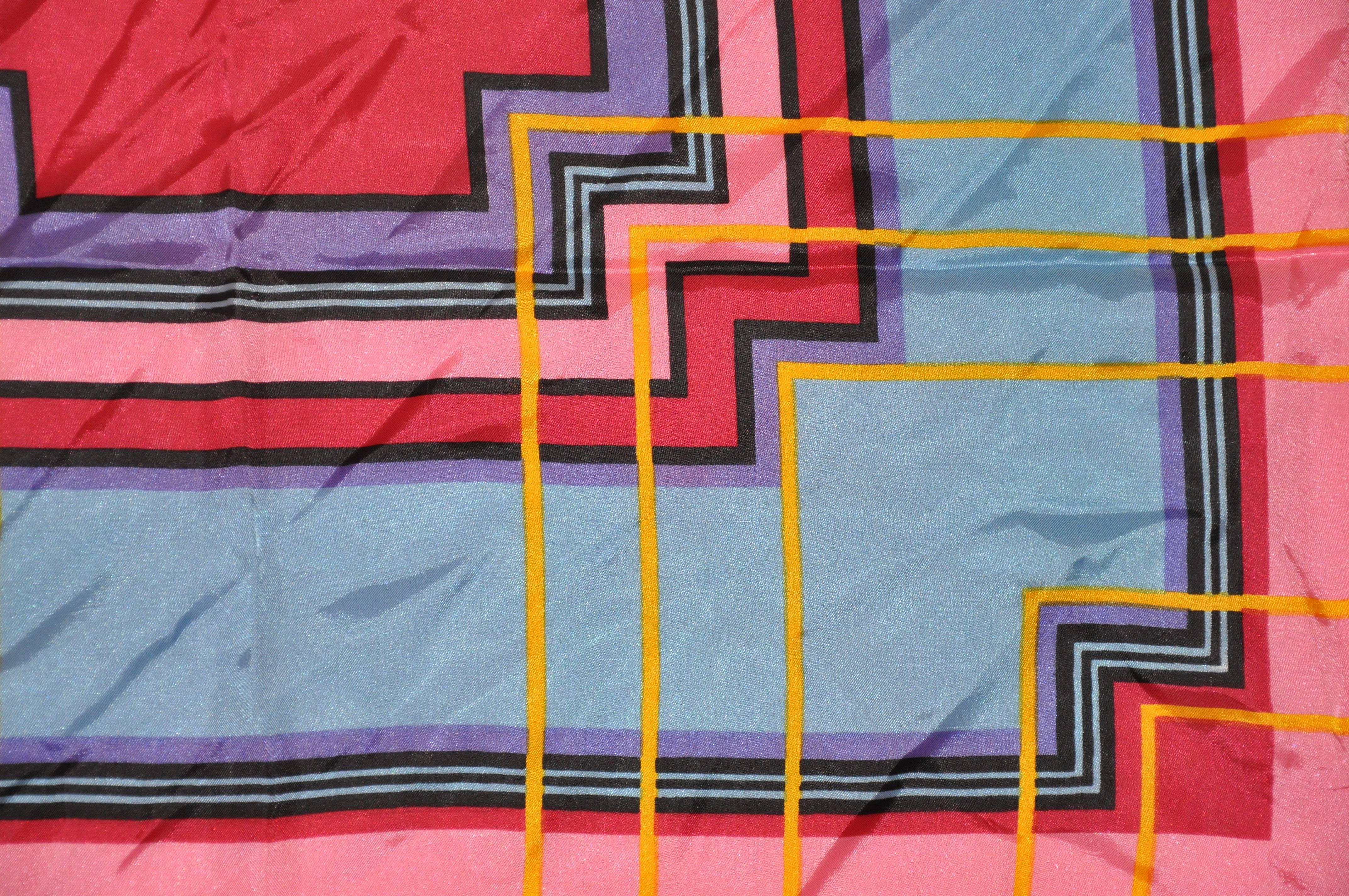      Wonderfully bold, this bold multi-color abstract accented with a wide pink border scarf measures 25 inches by 25 inches. Made of acetate in Japan.