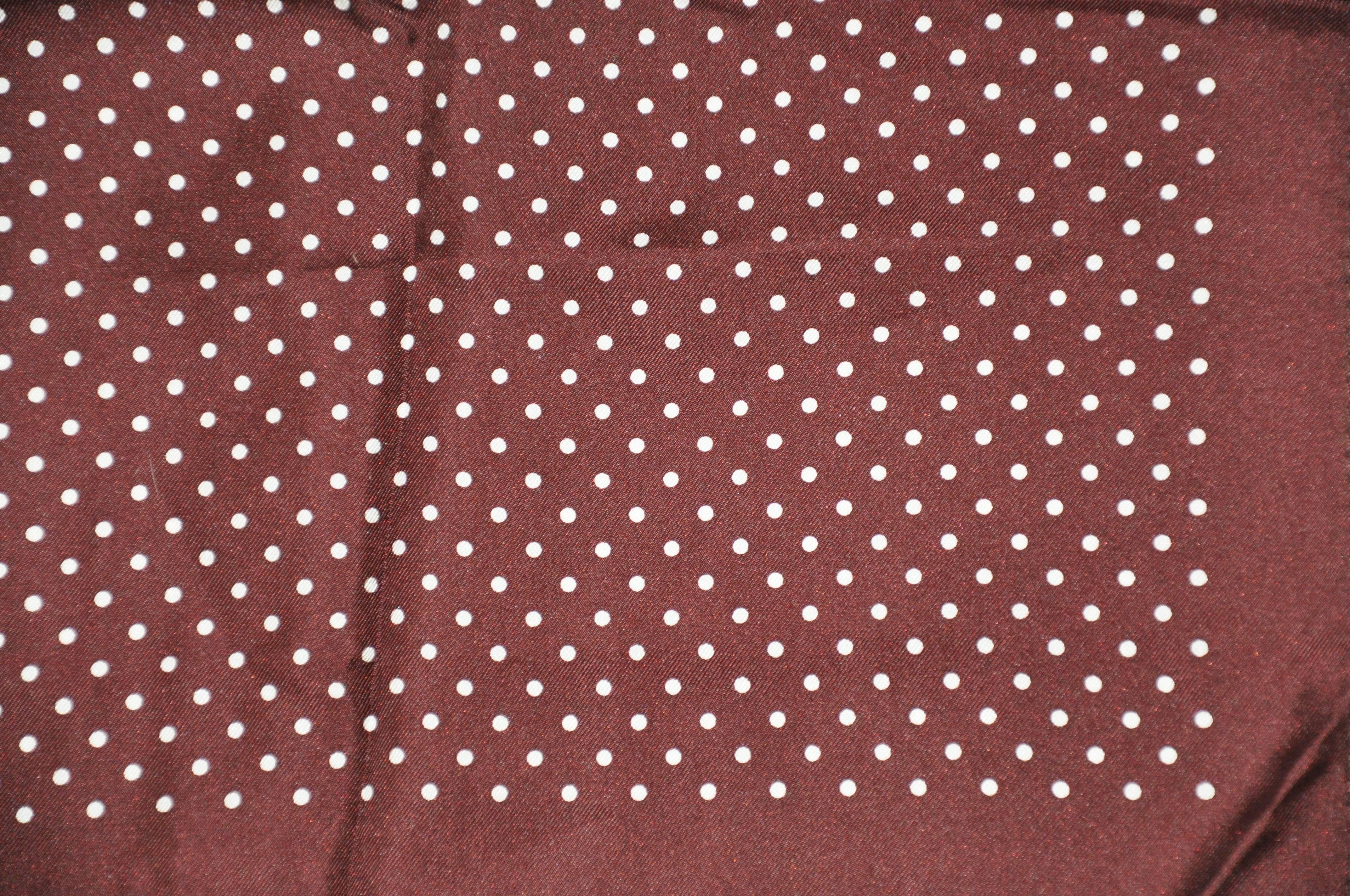        Classic brick burgundy surrounding a polka dot center silk handkerchief is accented with hand-rolled edges and measures 14 inches by 14 inches. Made in Italy.
