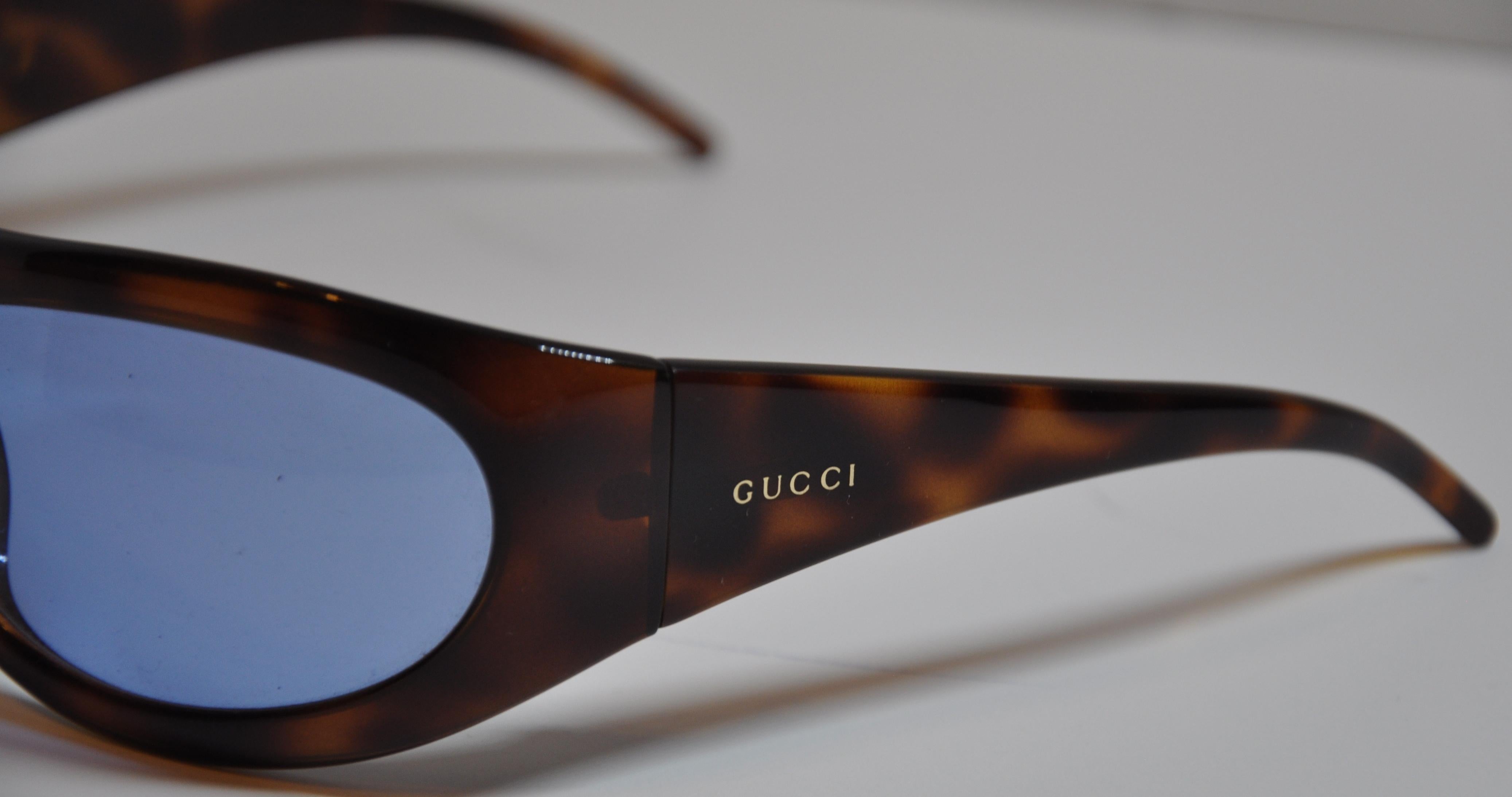        Gucci deep rich and warm tortoise shell sunglasses are accented with a blue-tinted lens. The front measures 5 6/8 inches across, height is 1 7/8 inches, and the arms measures 4 3/4 inches in length. Made in Italy.