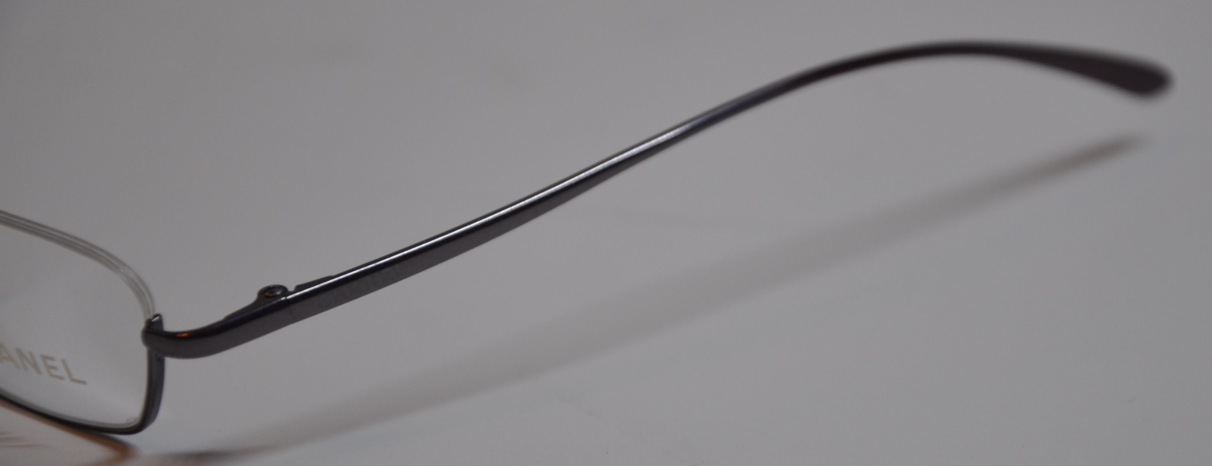        Les lunettes de lecture Chanel, merveilleusement intemporelles, en titane irisé, de couleur lavande et chaude, sont dotées de coins incurvés et de branches courbes. Le devant mesure 5 2/8 pouces de large. La hauteur mesure 1 pouce, et les