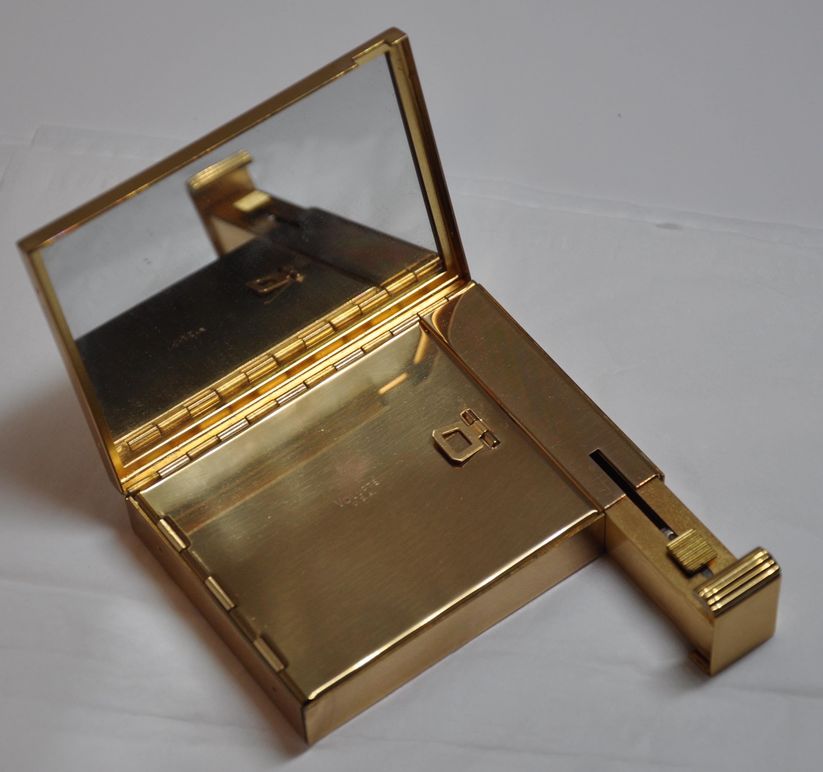        Volupte wonderful polished gold hardware compact is complete with lipstick holder, which locks the compact when not in used. Simply pull the lipstick holder out, and the compact will open up like magic. Unused compact with mirror as well as a