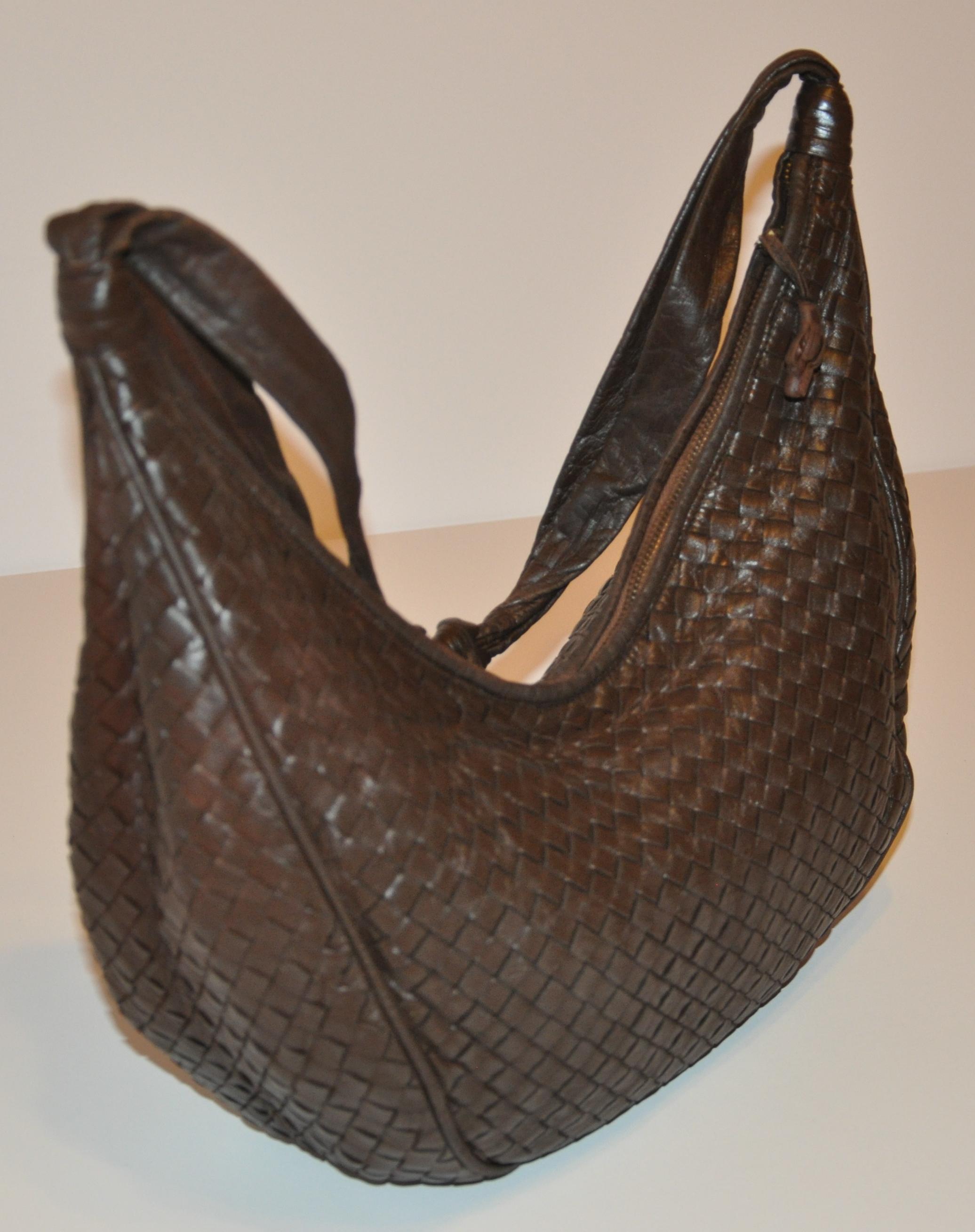        Bottega Veneta deep coco-brown woven lambskin zippered-top shoulder bag is detailed with lambskin piping throughout. The top zipper measures 17 inches. The interior has a large zippered compartment and is fully lined. The shoulder strap