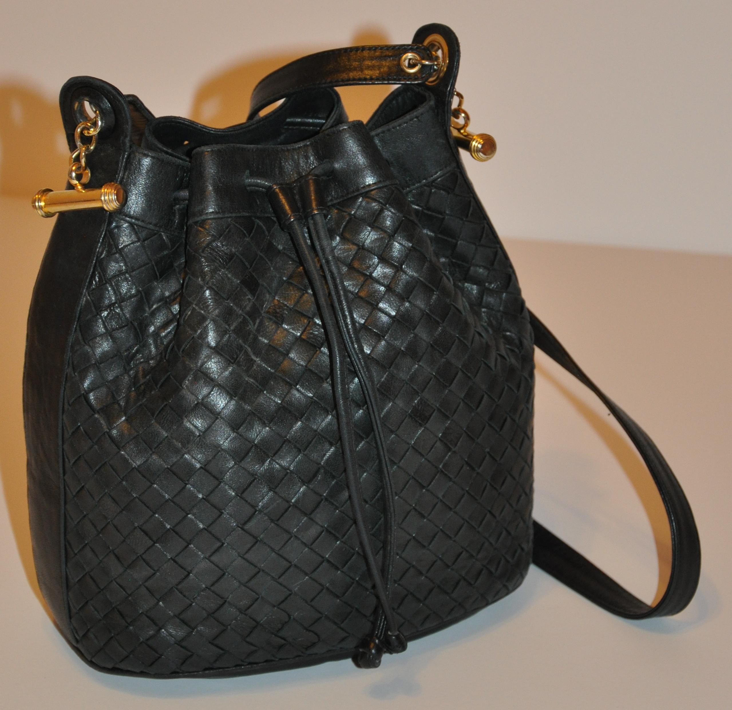        Siso wonderfully soft navy-black woven lambskin drawstring shoulder bag is detailed with gilded gold hardware. The drawstring is made of lambskin as well as the piping throughout. The height of the bag measures 9 inches. The bottom