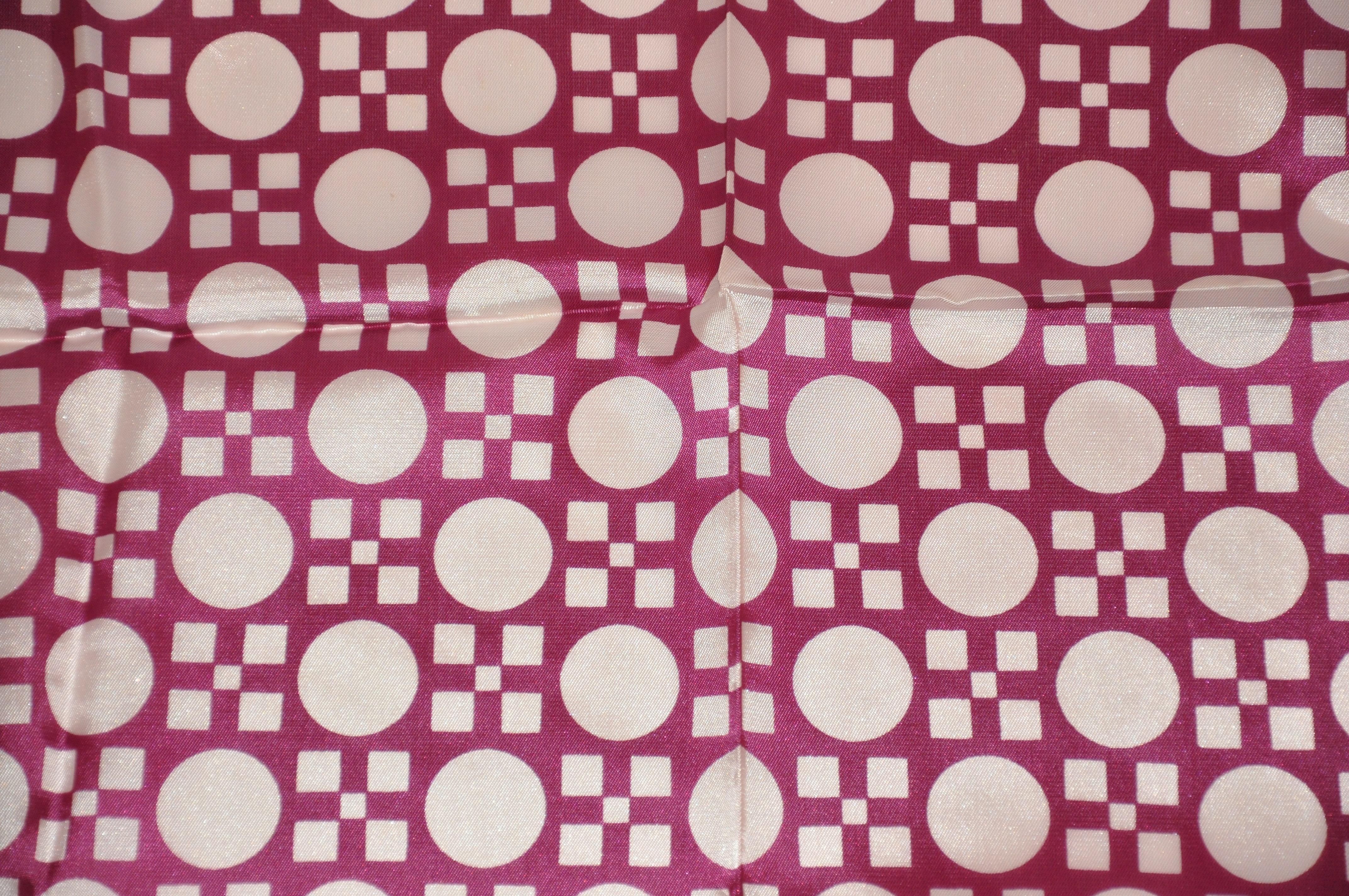        La sciarpa astratta in acetato di Morsly, nelle meravigliose tonalità del fucsia e del prugna, misura 26 pollici per 26 pollici. Bordi microcuciti e made in Italy.