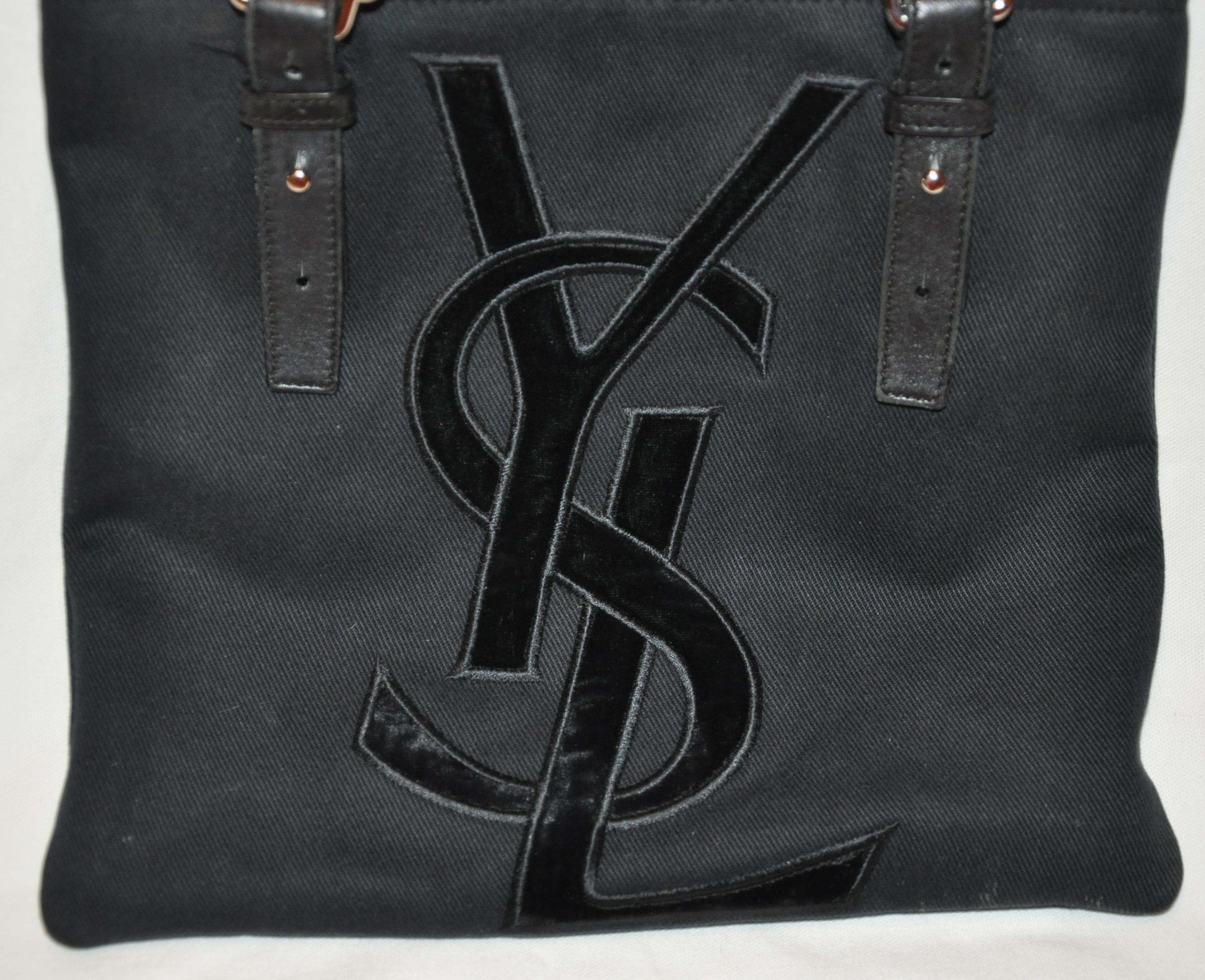       Yves Saint Laurent wonderful signature velvet monogram front adjustable double handle tote bag is detailed with adjustable handles measuring from 10 1/2 to 13 1/2 inches. The handles are combined with black calfskin as well as black canvas