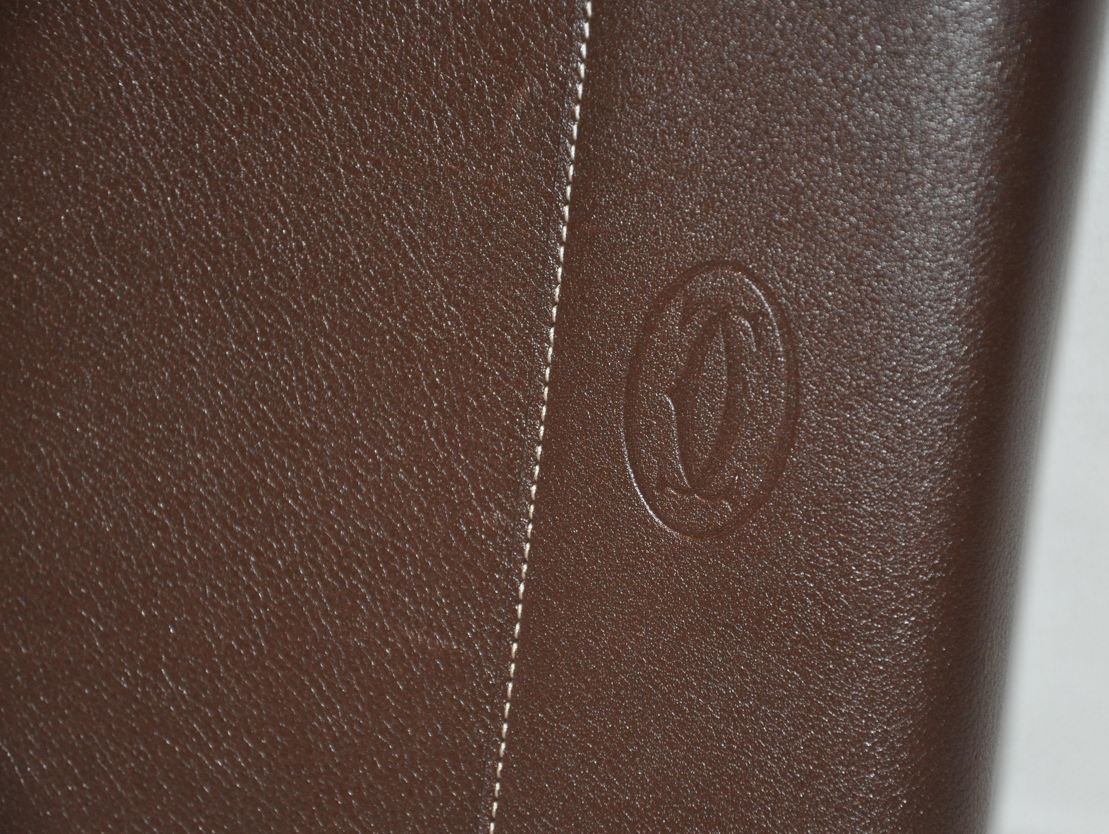        Cartier wonderful signature textured coco-brown calfskin covered notebook detailed with their signature monogram on the exterior cover. The interior's right corner has their signature 