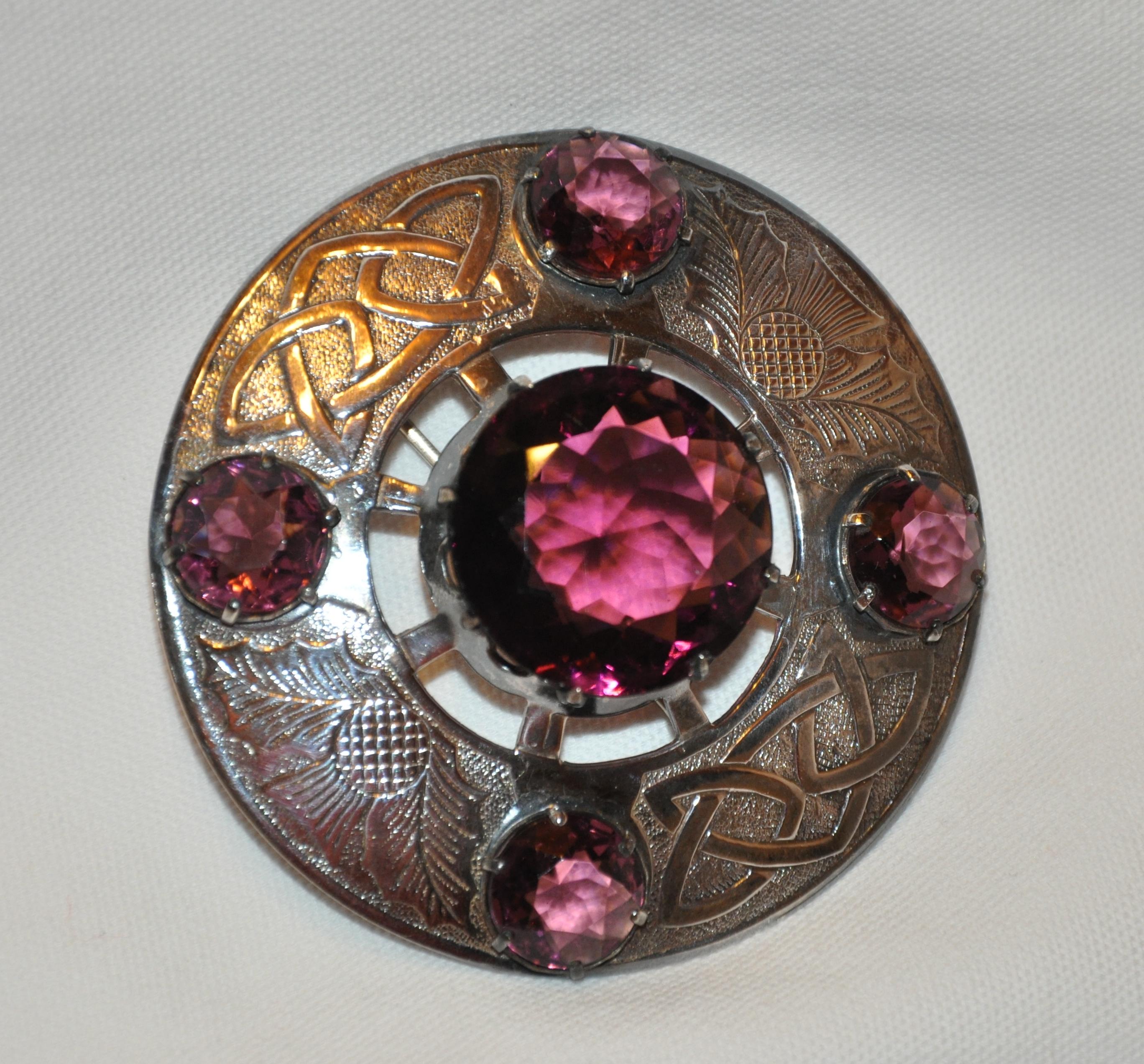        Huge rare huge silver Celtic etched detailing brooch is accented with clear violet stones. 8 prongs holds the center stone, while the surrounding stones are held in place with 6 prongs. This wonderful brooch, made in Great Britain, before