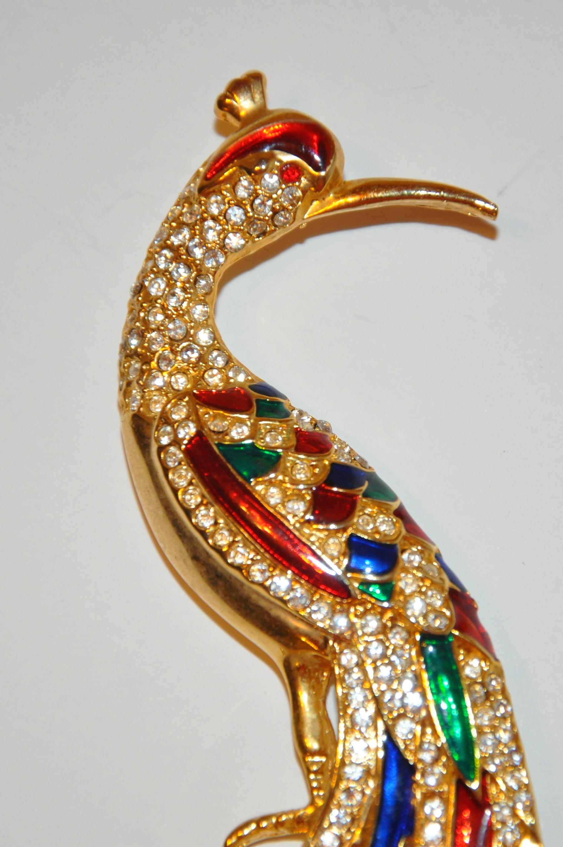       Cette énorme et magnifique quincaillerie en vermeil doré est sertie de plusieurs couleurs d'émail bleu lapis, vert irlandais et rouge rubis, accentuées de plusieurs faux diamants. Cette magnifique broche mesure 5 2/8 pouces. La hauteur mesure