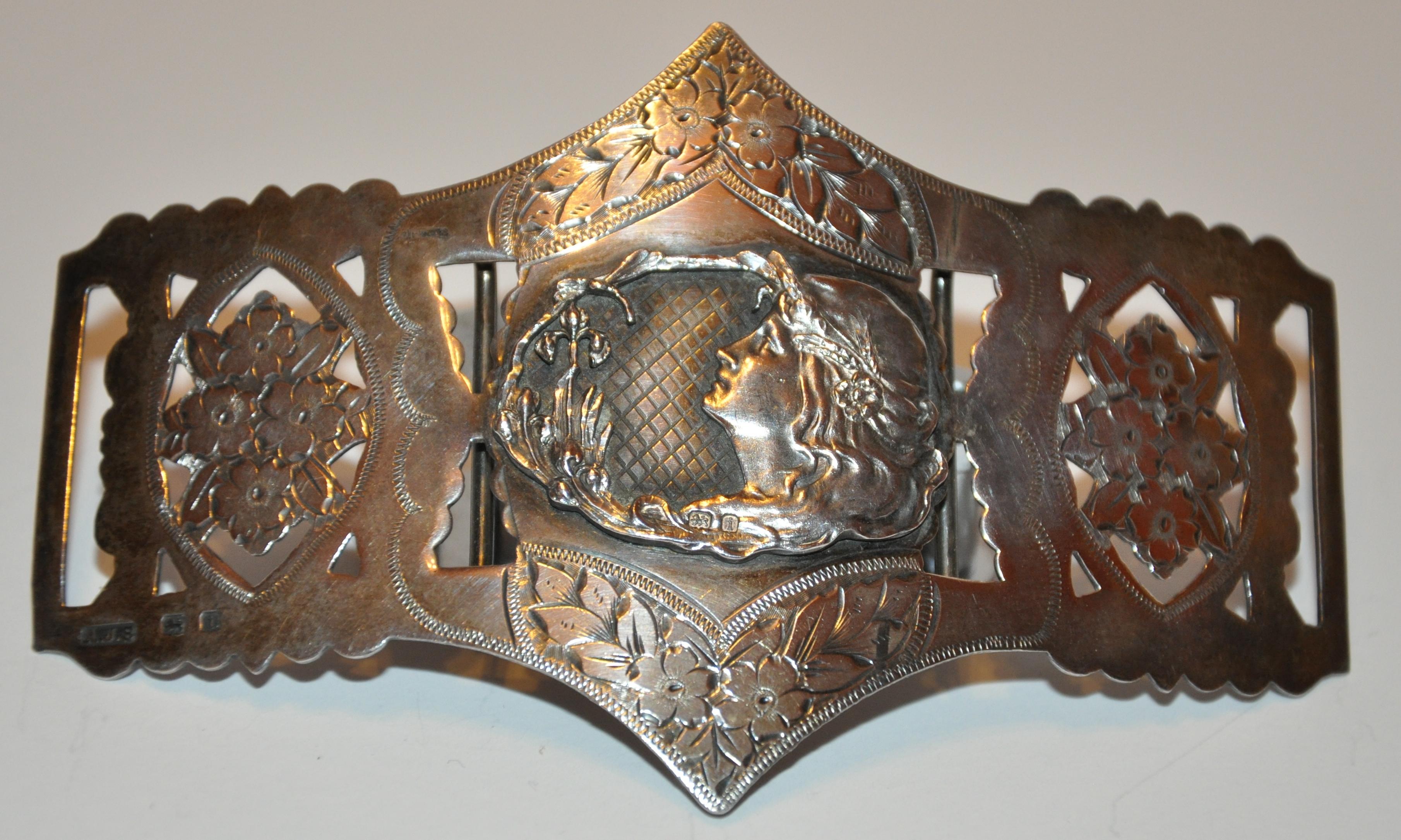          Magnificently detailed, this 3-piece Victorian-era etched Silver buckle of beautiful florals on all three pieces highlights the center buckle with inlaid 