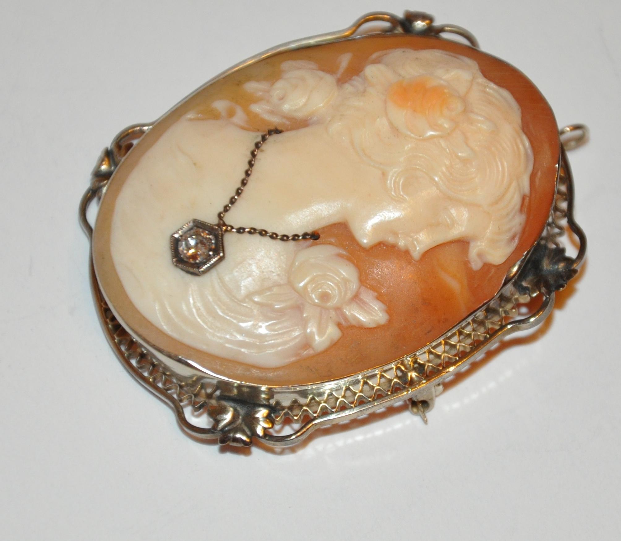        This exquisite Victorian Cameo surrounded with 14K yellow gold filigree is accented with a .10 carat diamond pendant delicately hanging on necklace within the cameo. This wonderful cameo can be worn either as a brooch or pendant if desired.