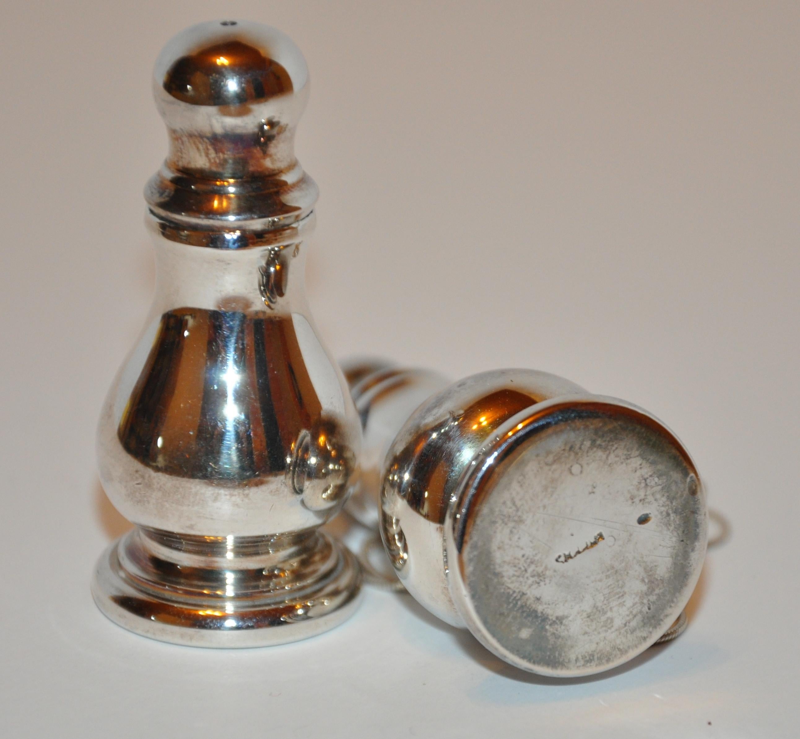        These pair of heavy sterling Silver salt & Pepper shakers features a screw-top. Makers' mark is etched in the center of the base. The height measures 2 1/8 inches, circumference along the base measures 1 inch. 