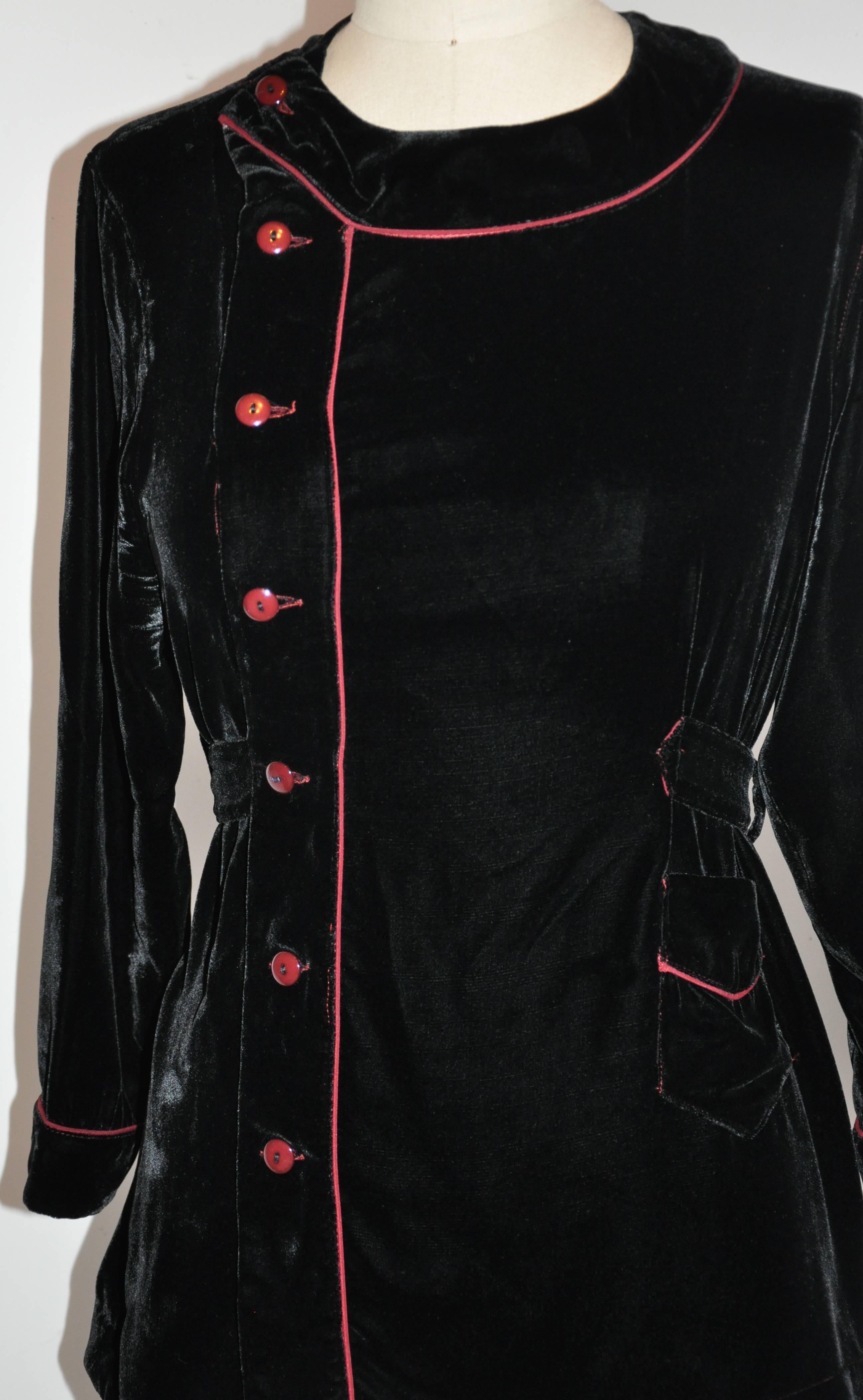         Jean Paul Gaultier black velvet top is accented with Bordeaux silk piping and matching buttons. The waistband is adjustable with three buttons on either side of the backside. The front has four buttons as well as a patch pocket with