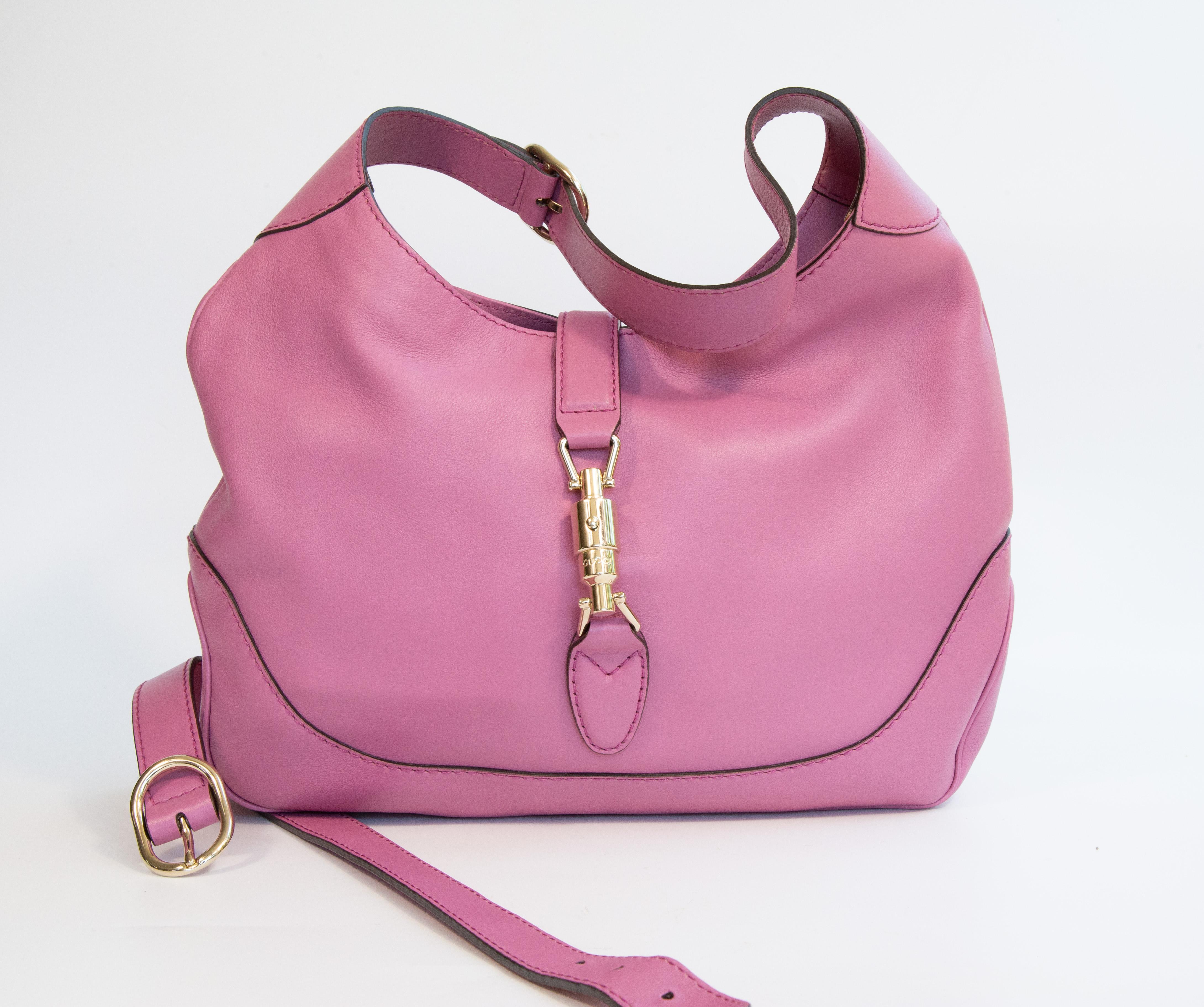 Eine Gucci Jackie aus rosafarbenem Leder mit leicht goldfarbener Hardware. Der Innenraum ist mit beigem Stoff ausgekleidet und verfügt neben dem Hauptfach über drei Seitentaschen, von denen eine mit einem Reißverschluss versehen ist. Der Beutel kann