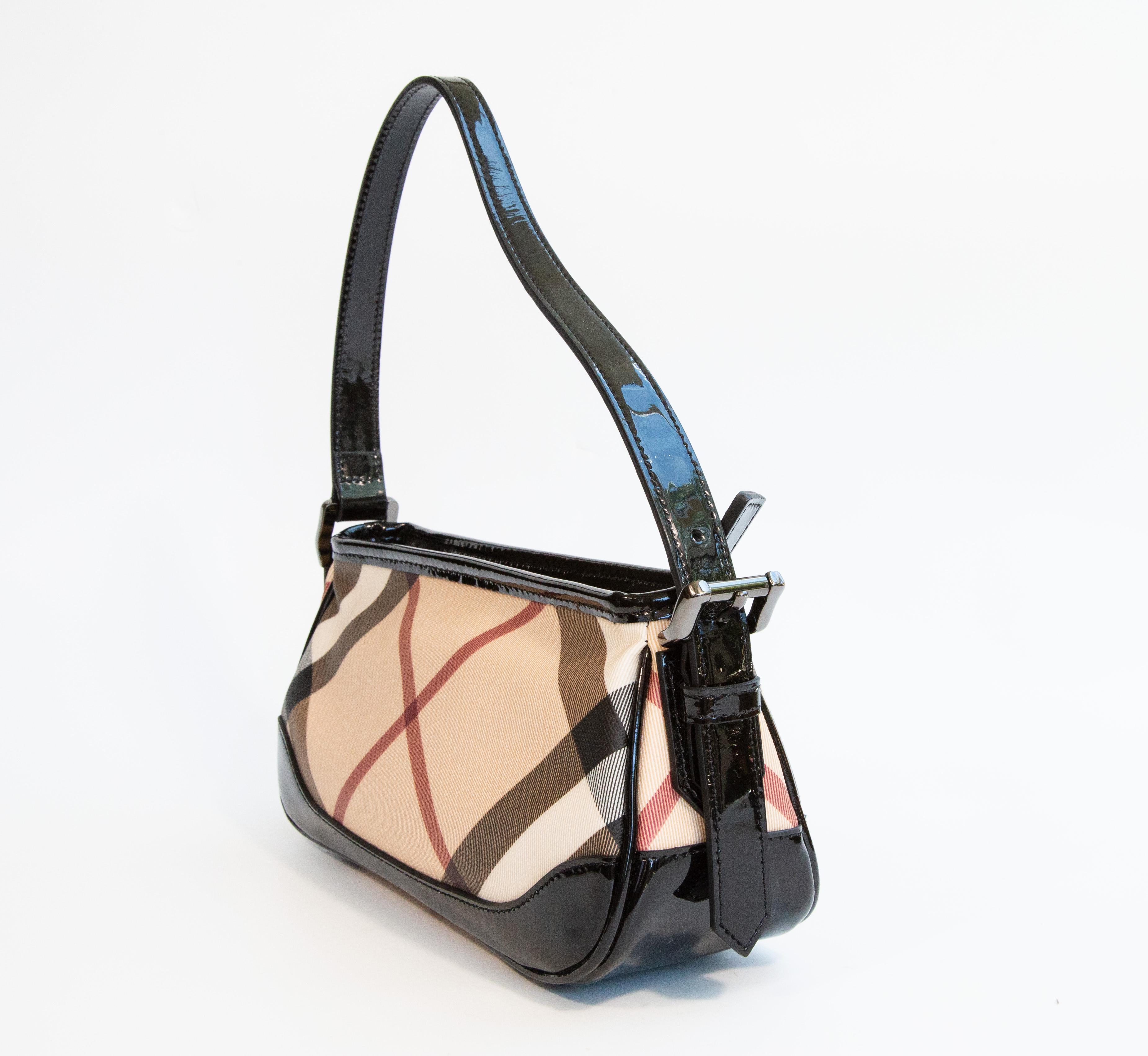 Un sac à bandoulière/une pochette/un sac de soirée Burberry. Le sac se compose d'une toile PVC à carreaux Nova, d'une garniture en cuir verni noir et d'une quincaillerie de couleur étain. L'intérieur est doublé de tissu beige et à côté de  Dans le