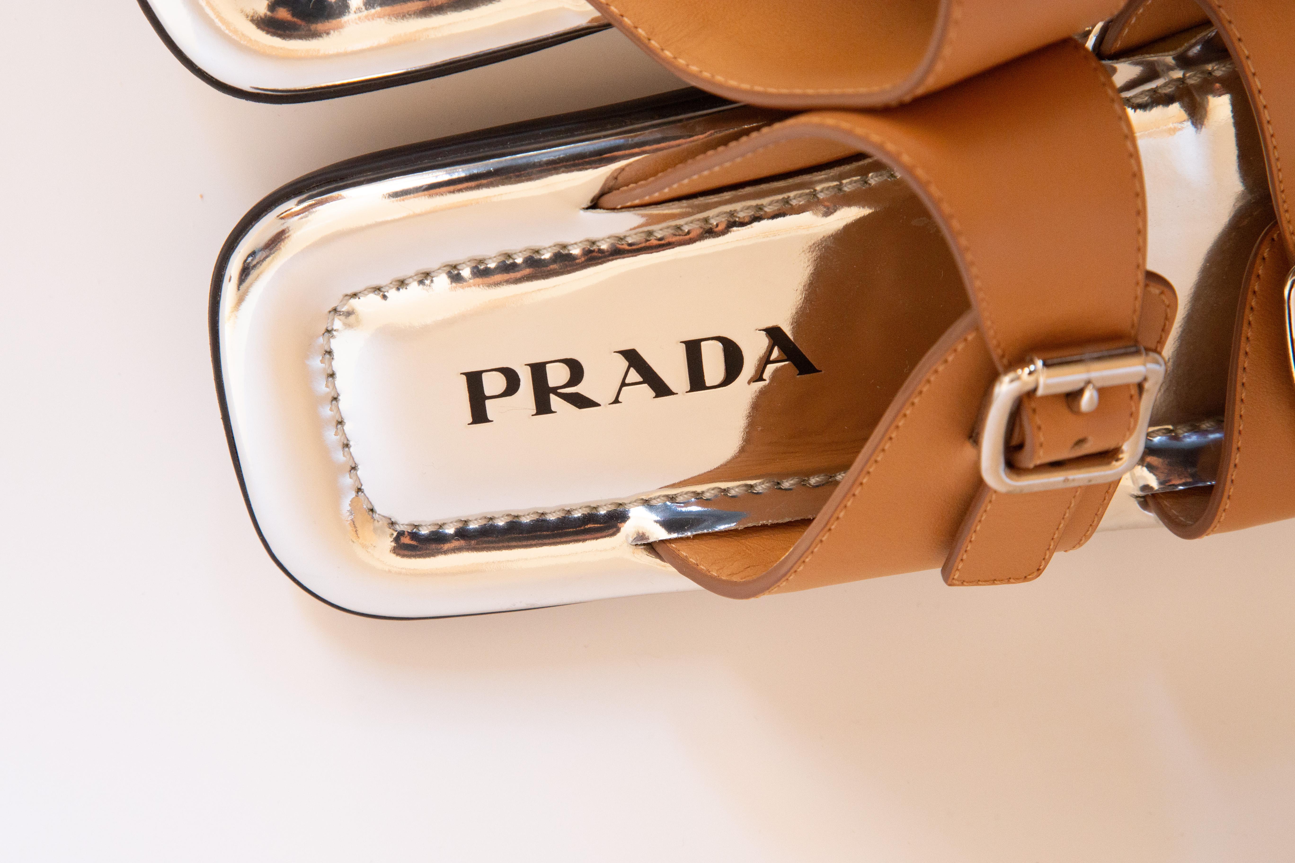 Sandali di Prada in pelle marrone con suola interna in pelle argentata e finiture argentate. I sandali sono stati indossati una o due volte e sono in perfette condizioni. La lunghezza della suola interna è di 25,5 cm. Taglia 38. Compreso il