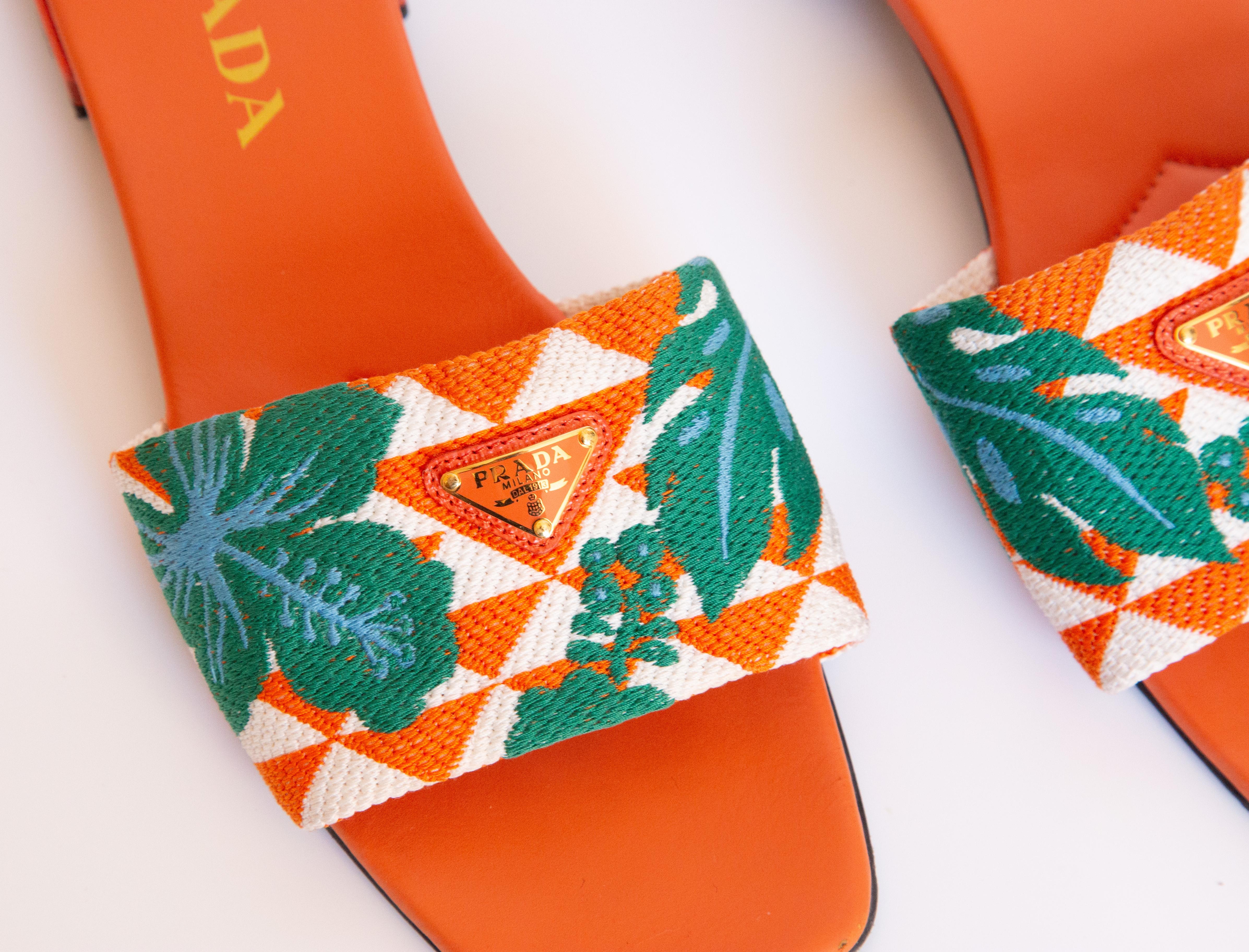 Scivoli Prada in tela multicolore con suola interna in pelle arancione. Le diapositive presentano la targhetta triangolare in metallo con logo Prada sul davanti. Indossate occasionalmente, in ottime condizioni, i segni d'uso sono visibili solo sui