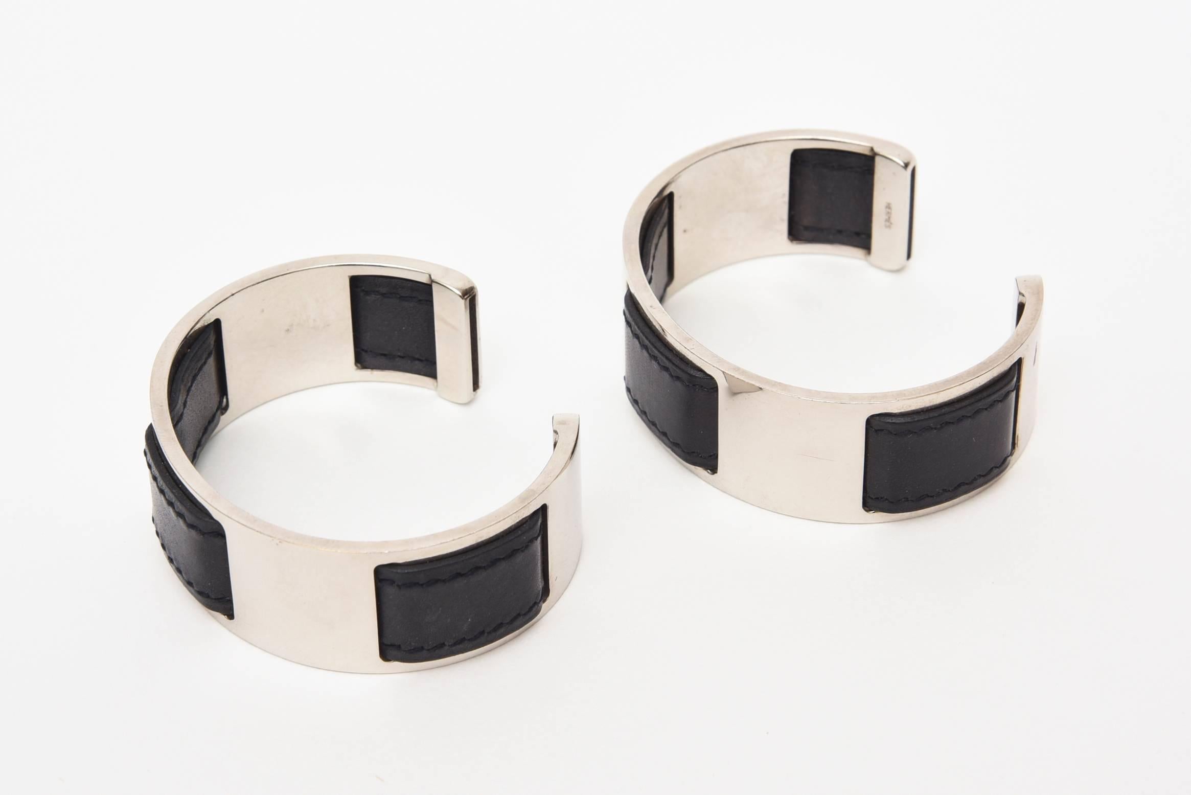 These classic but unusual early bracelets designed by Martin Margiela for Hermes are black leather and chrome. They must be worn as a pair to give the great effect. One can be worn on each wrist or certainly together. Black leather is interspersed