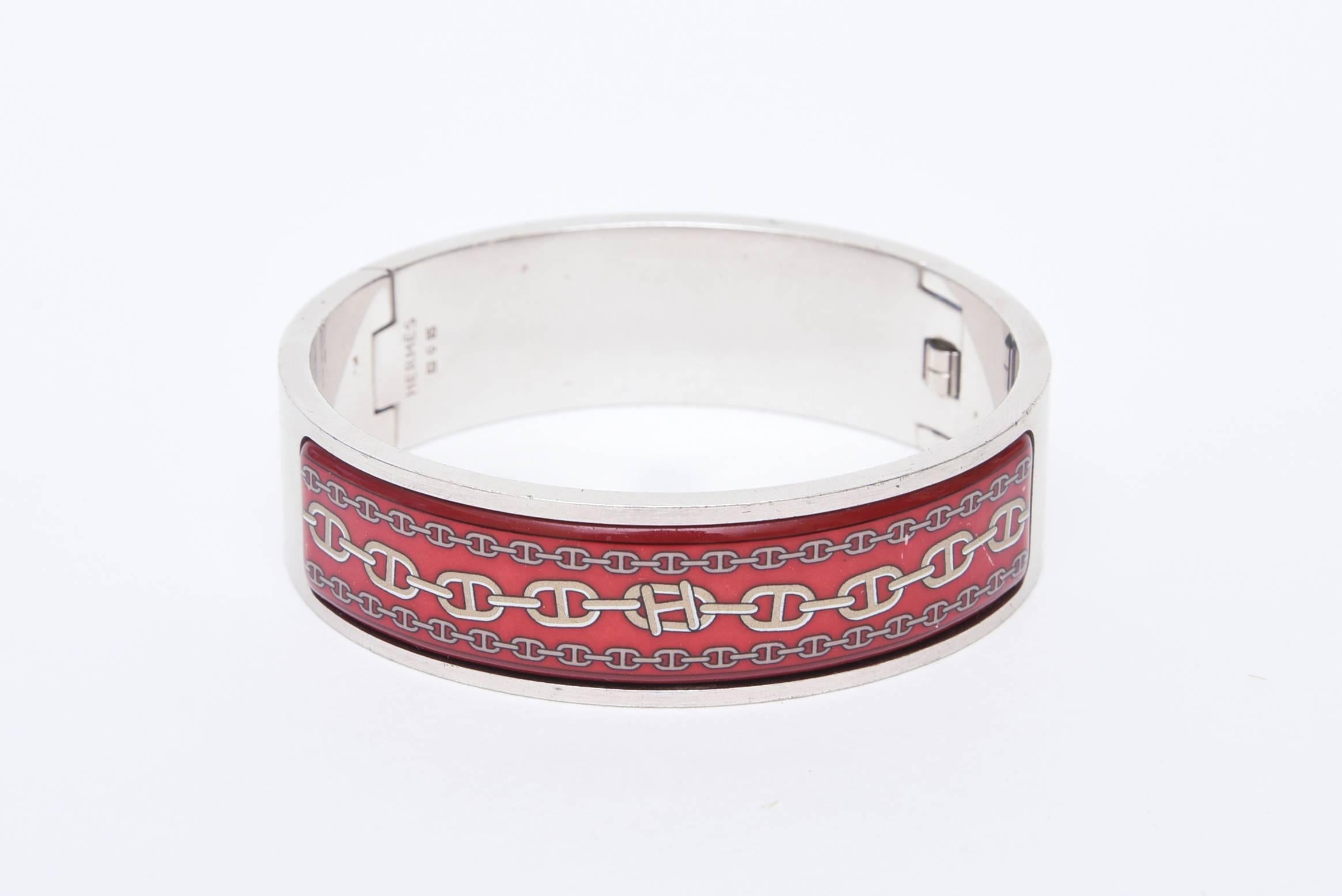 This rare and early enamel and brushed stainless steel closed bracelet was designed by Martin Margiela for Hermes around 1998.
The enamel design is Hermes links with the H in the center.
This is a rolled hinged bracelet clasp. This is