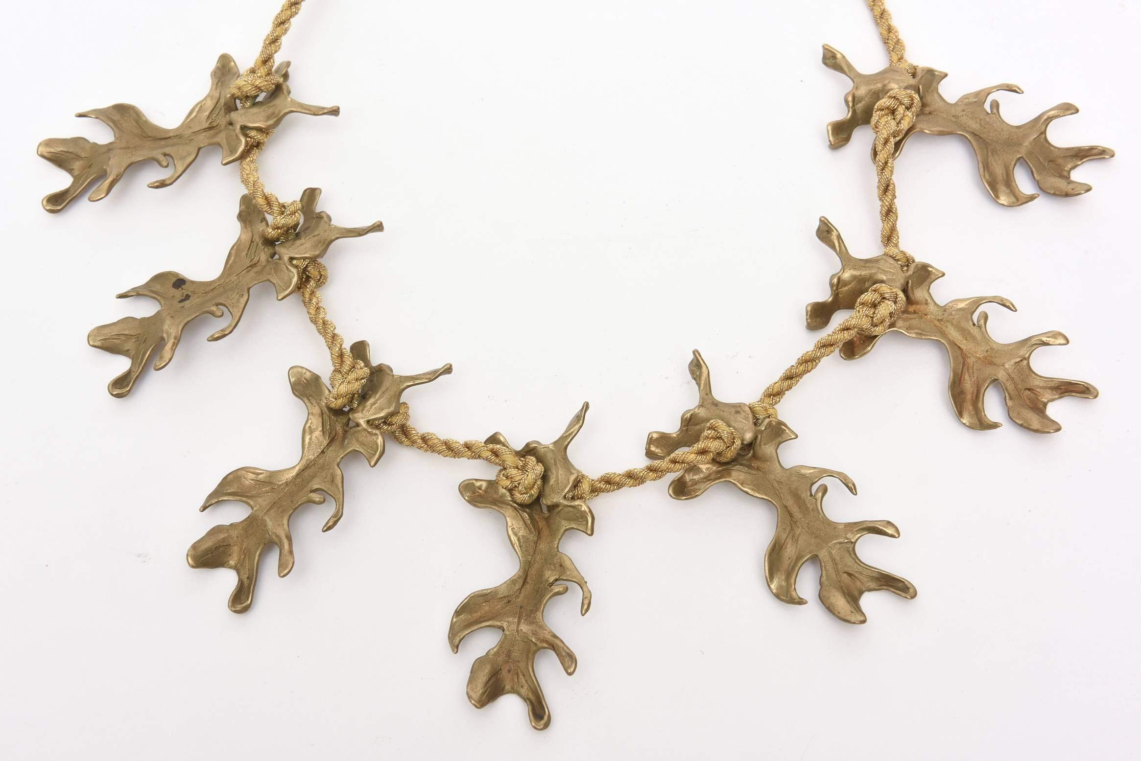 This vintage necklace by Mary McFadden has beautiful gold silk metallic braided rope that houses the 6 bronze pendants that hang from it. It simply ties around the neck so one can make it fit as low or high as possible.The leaf shaped bronze