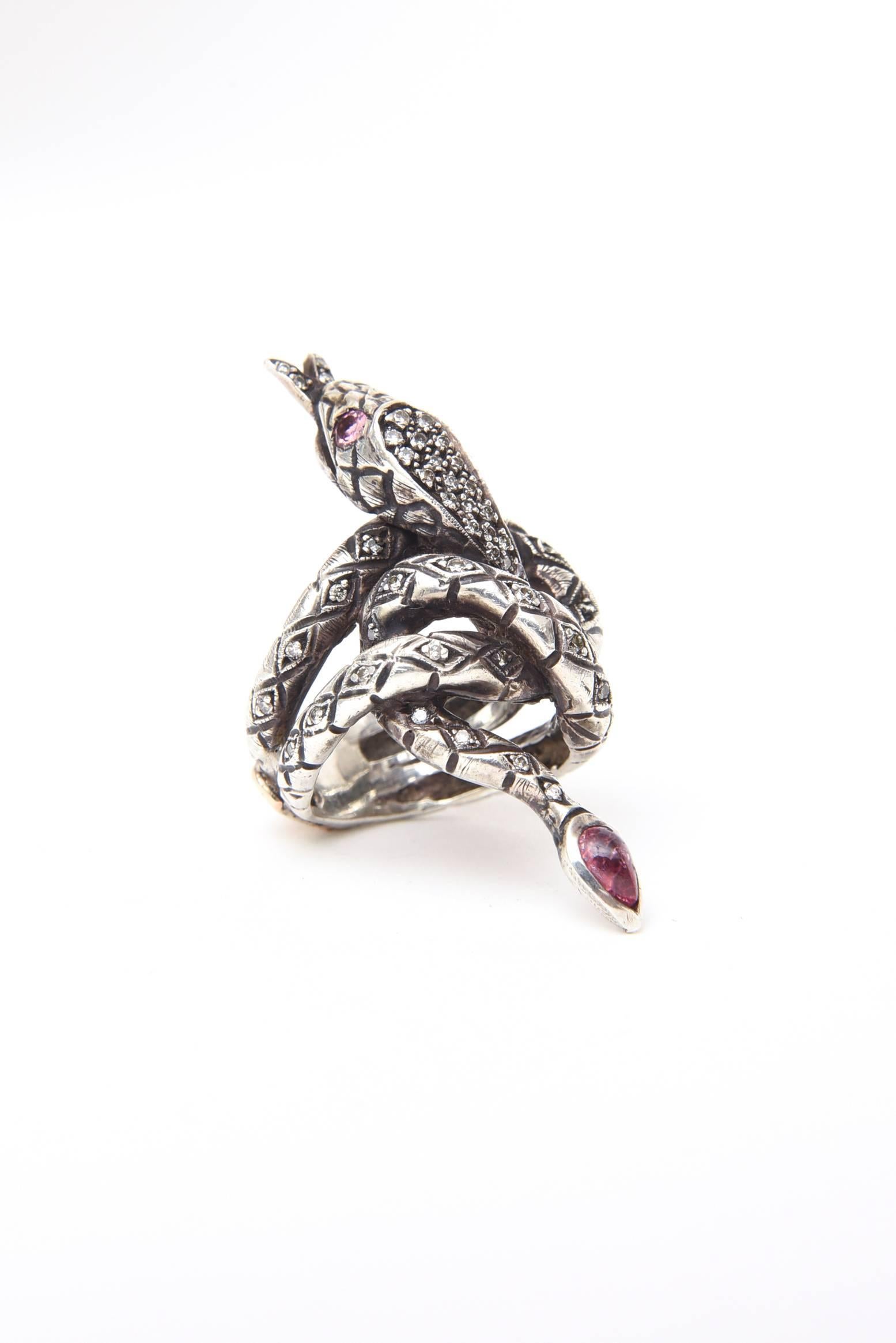 This dramatic, elongated, serpent/snake ring has diamonds set in Sterling Silver.
The coiled serpent has a tourmaline tail and ruby eyes. 
Signed KK in 14k gold n the back of the band.
Size 5 ring, 2 inches long, by 1 inch wide, by 1 1/4 high. 
This