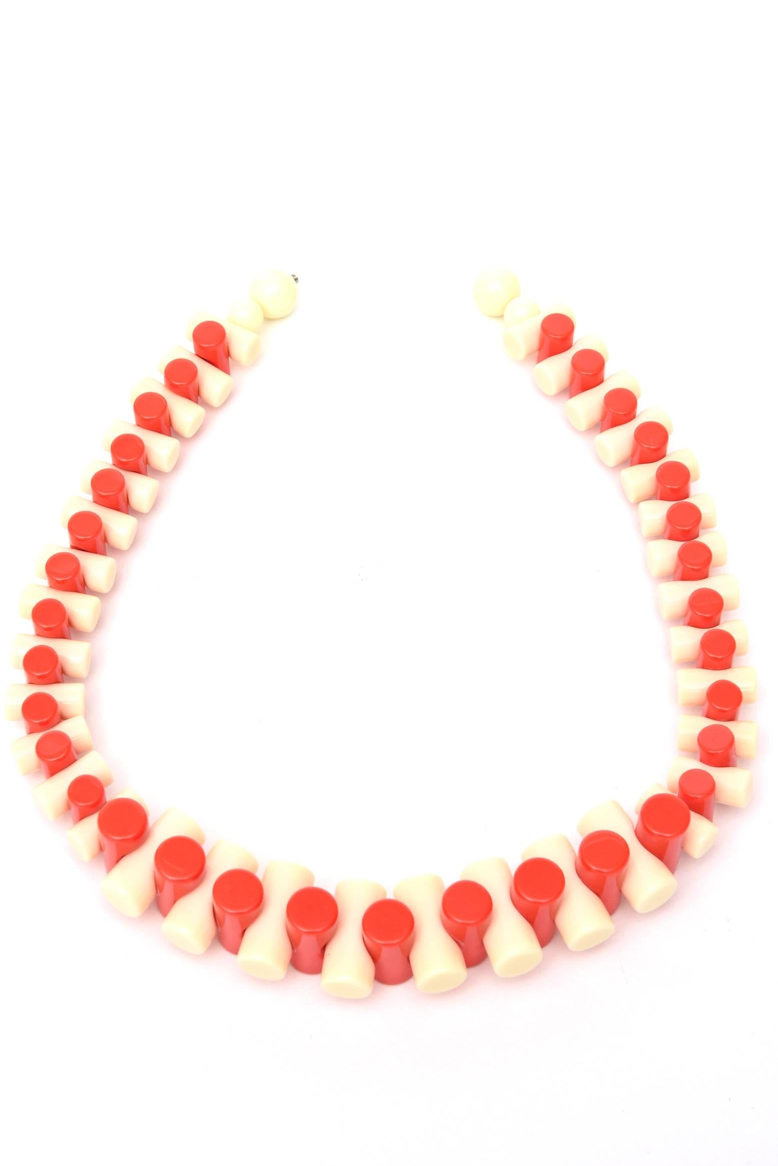 Alternating colors of orange and creme resin make up this sculptural necklace that makes a statement. It graduates in size of the tubular formed resin. It is french from the 90's. Perfect for resort wear and summer 2022. This is also wonderful for
