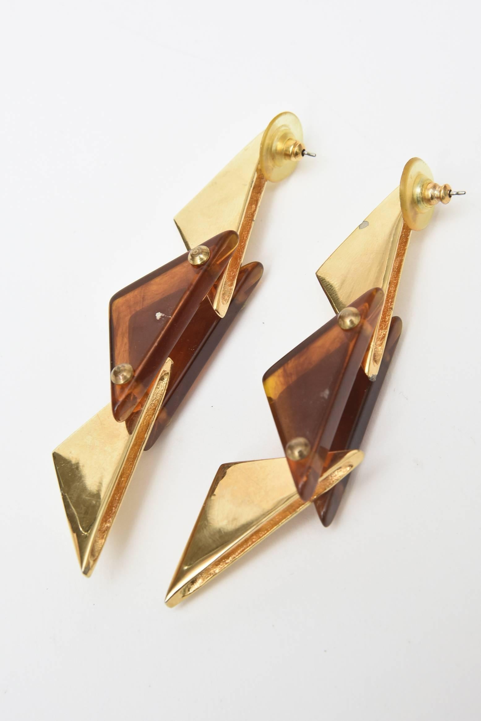 Triangles meet tortoise resin in these great pair of vintage pierced dangle earrings.They have sculptural form to them as alternating brass plated and tortoise lucite triangles are inverted. They are modern and make a great statement.  Their length