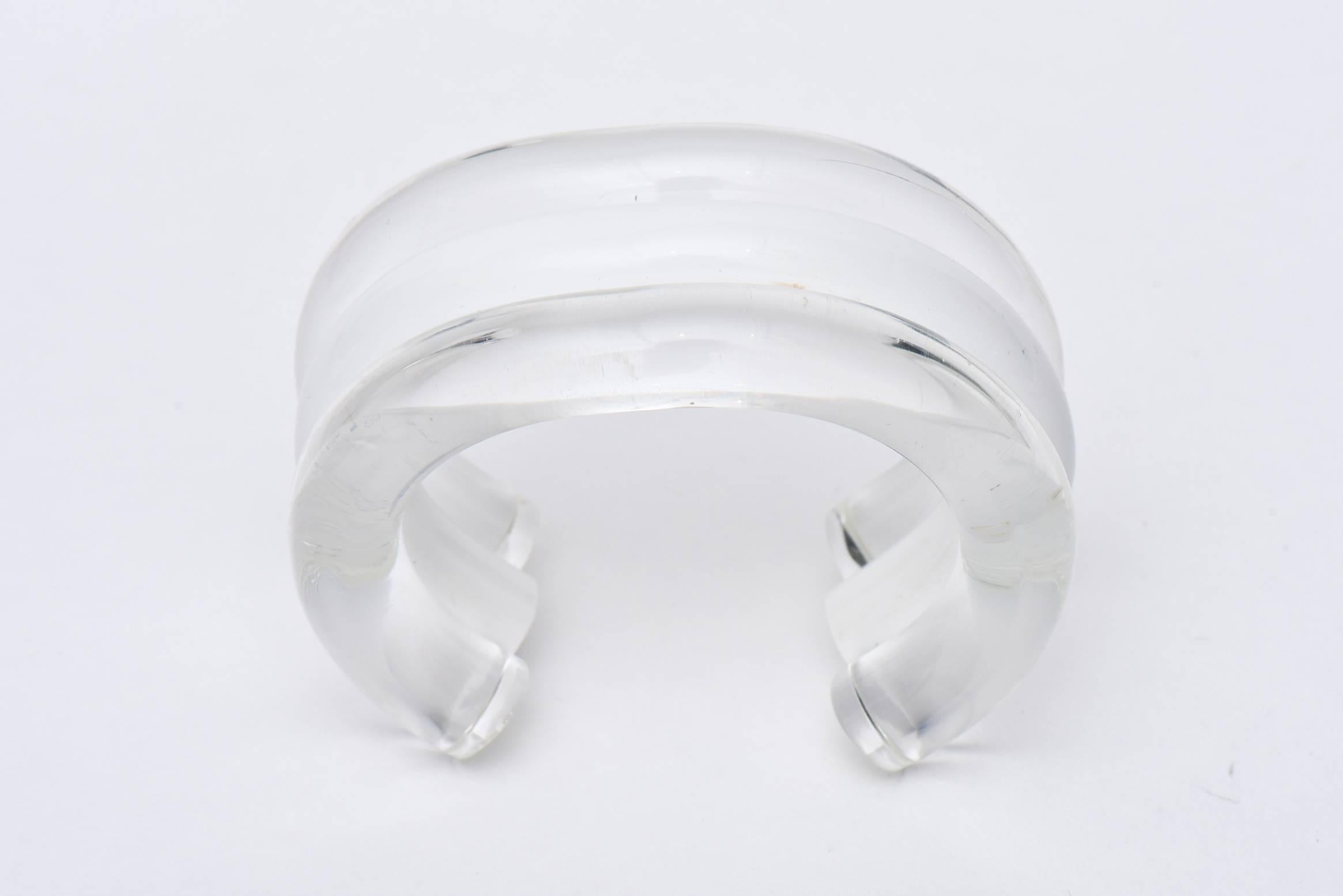 The bands of clear, white and then clear again make this very chic chunky lucite cuff bracelet from the 80's so wearable and fun! It is designed by a famous Californian artist named Judith Hendler who worked in plastic jewelry at the time. This will