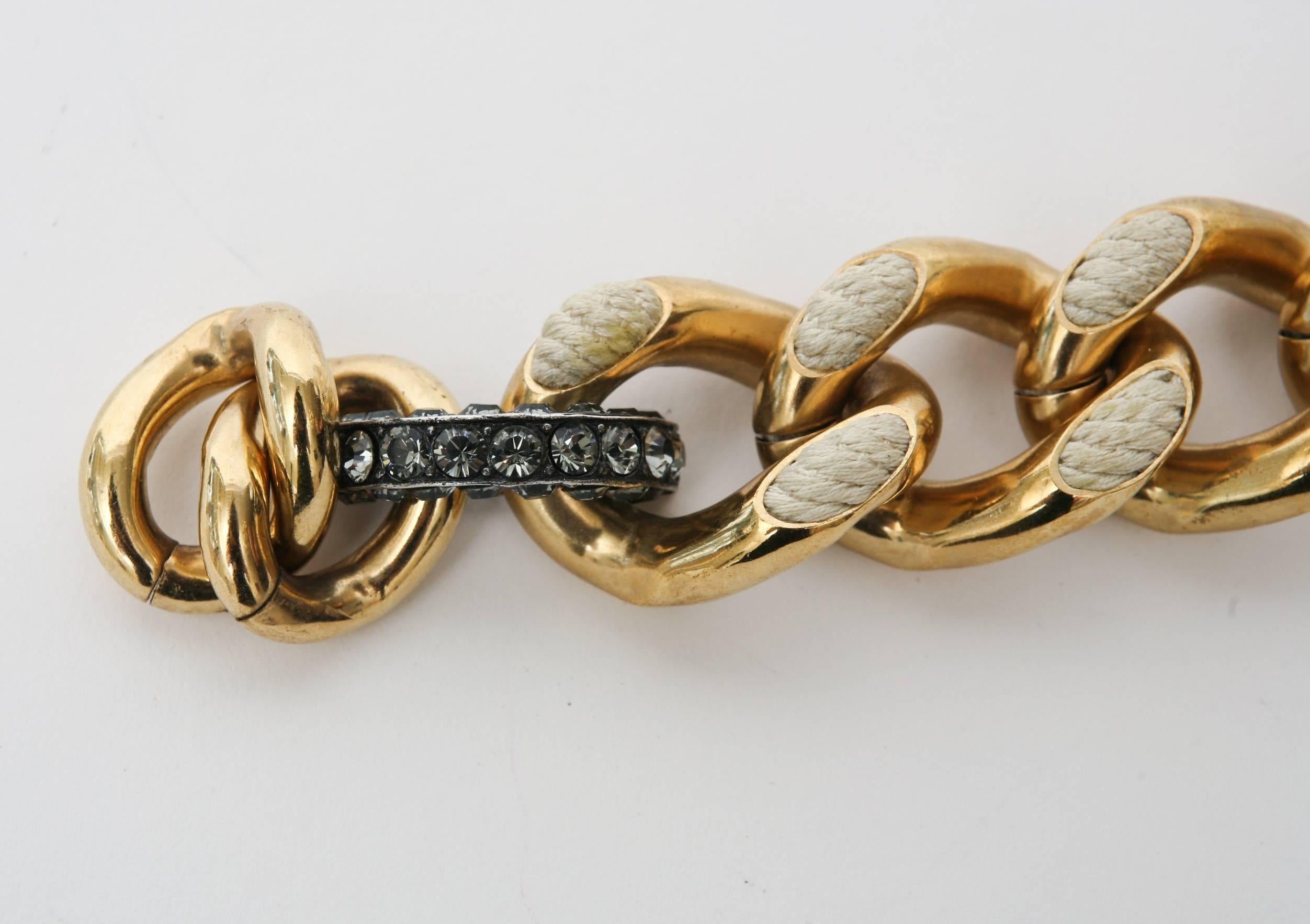 This never worn spectacular chic Albar Elbaz Lanvin tagged gold plated link/chain bracelet
has many components to it.It is off white braided rope raised resin mixed in with dark blue Swaroski dark blue crystals as the toggle clasp and a pin like bar