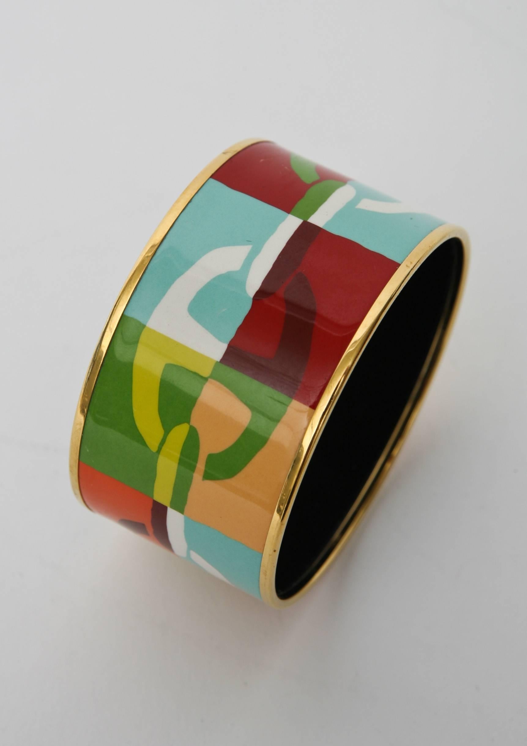 The luscious juxtaposition and play of colors in this Signed Hermes wide bangle cuff bracelet are a feast for fashion. It is enamel over metal and two gold plated thin bands are on both sides; top and bottom.
it comes in it's own original box. It