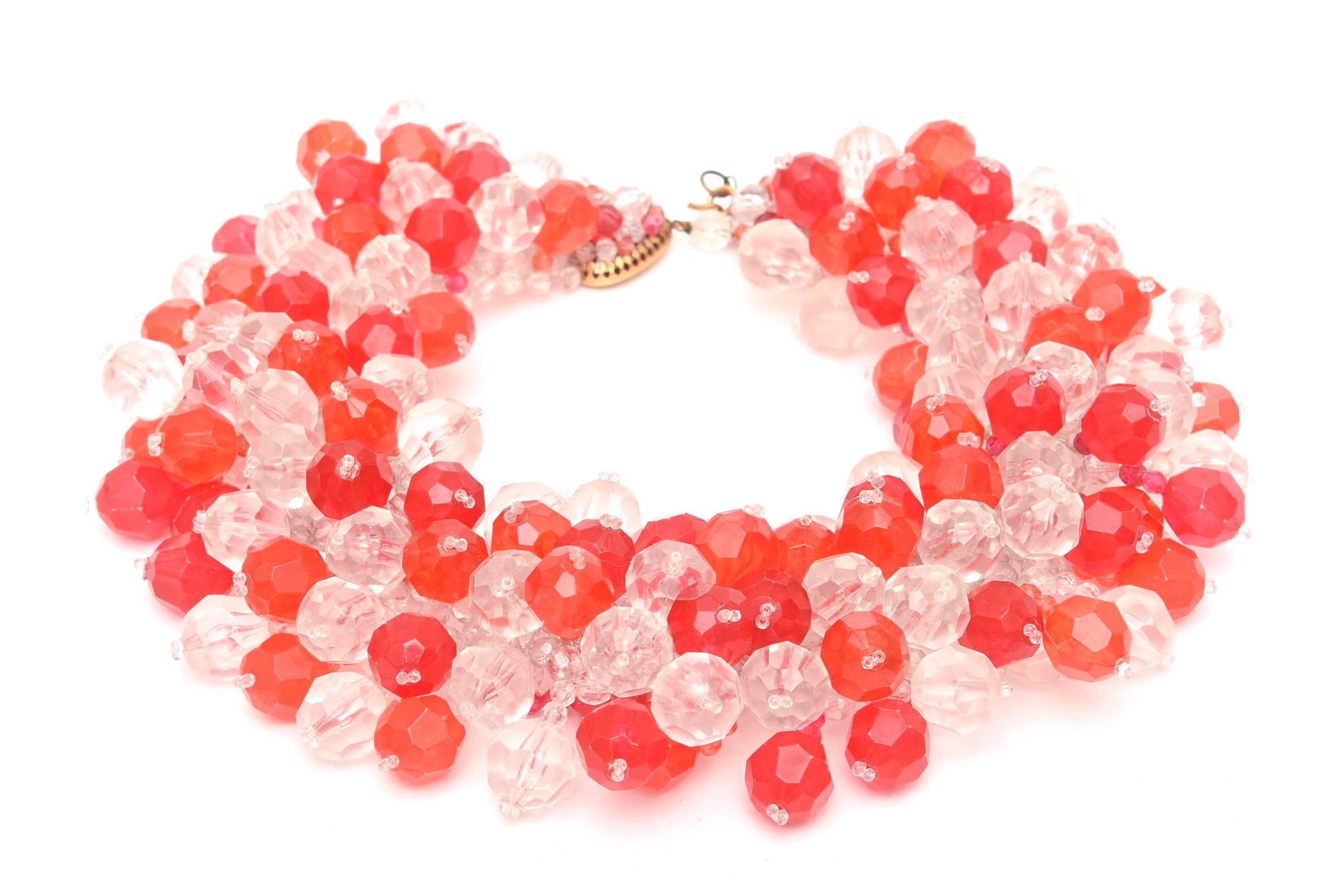 This amazing and arresting Italian vintage cluster of pop hued plastic beads in orange/red and interspersed with crystal lucite clear beads is so dramatic on the neck. It is hallmarked Made in Italy Coppola e Toppo. It was commissioned by Emilio
