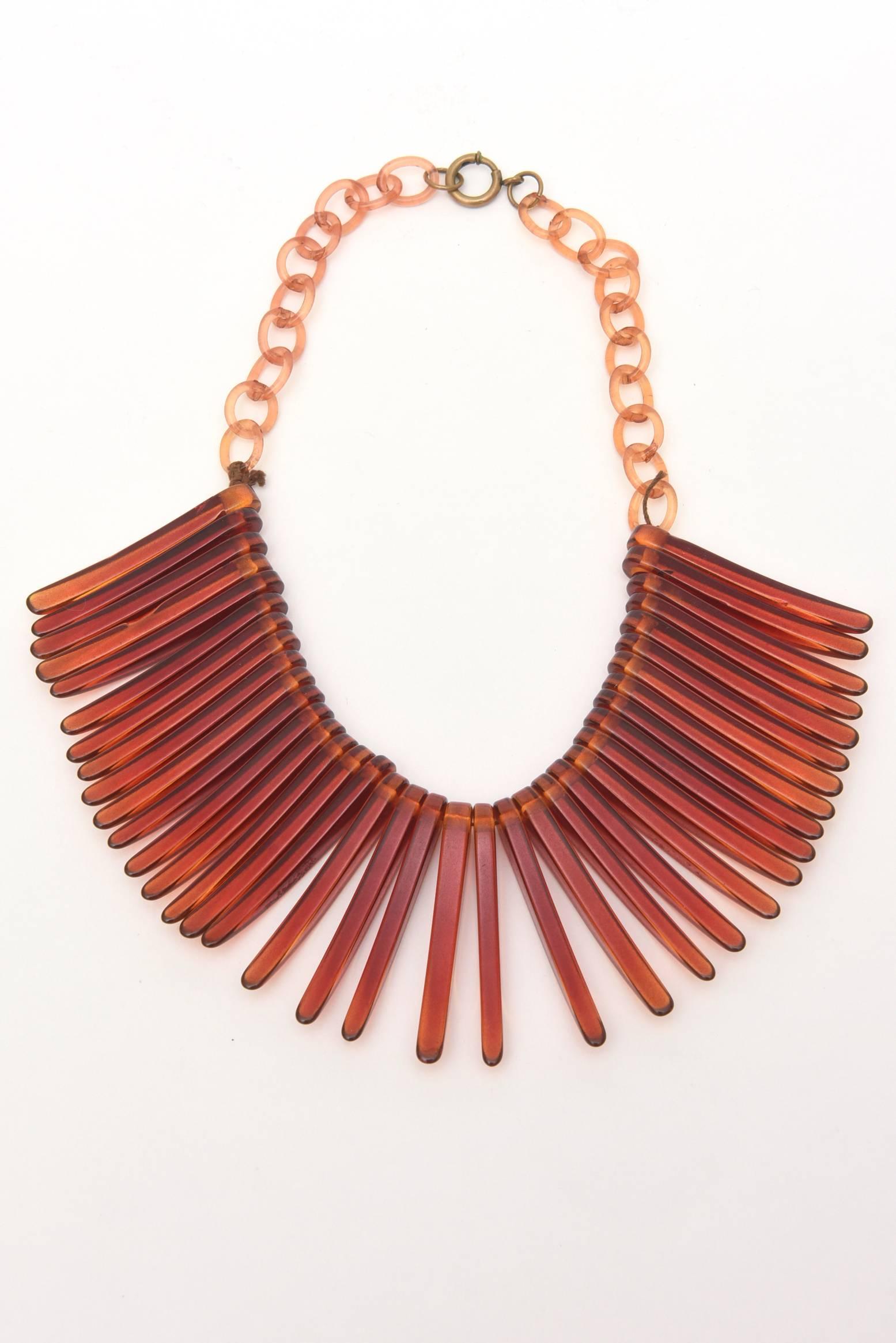 This very in vogue collar choker vintage resin necklace looks like fringe. It is tortoise like in color with resin links in a lighter amber color. It lays beautifully on the neck. A great piece for any wardrobe. Fringe is in, hot and back! It is