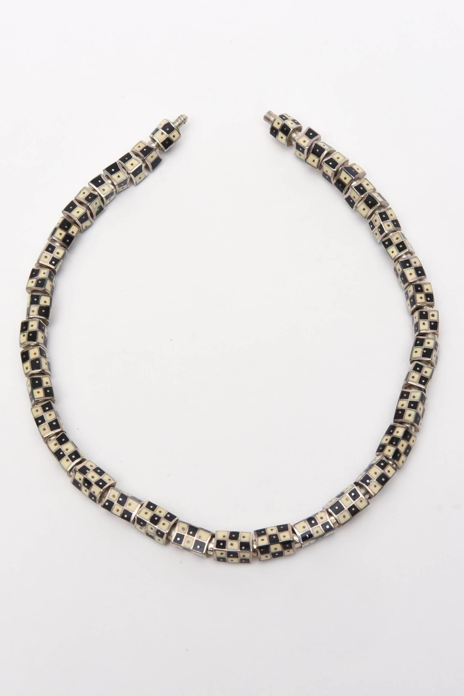 This gorgeous strand of black and off white enamel set against sterling silver vintage neck collar necklace is so sculptural with it's graphic designs of the art deco era. It is now timeless, classic and fabulous. Each enamel link has movement on