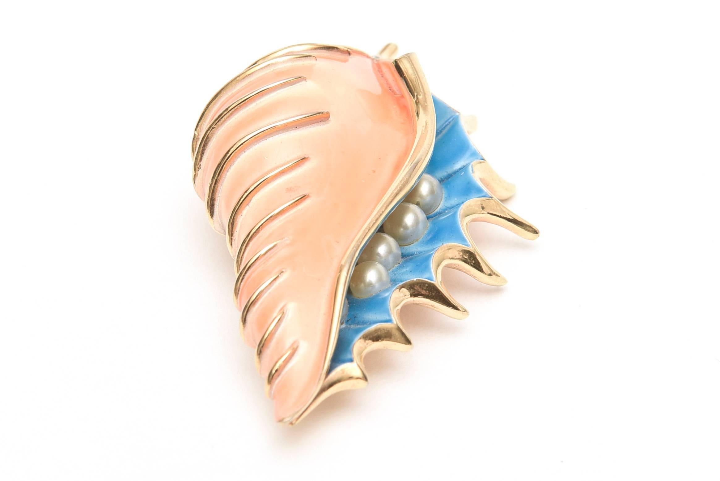 This beautiful enamel vintage pin signed Trifari has the gorgeous juxtaposition of the coral and sapphire blue against the gold plated metal. The interior of the shell is faux pearl. This is a now a beautiful and hard to find Trifari pin to come by