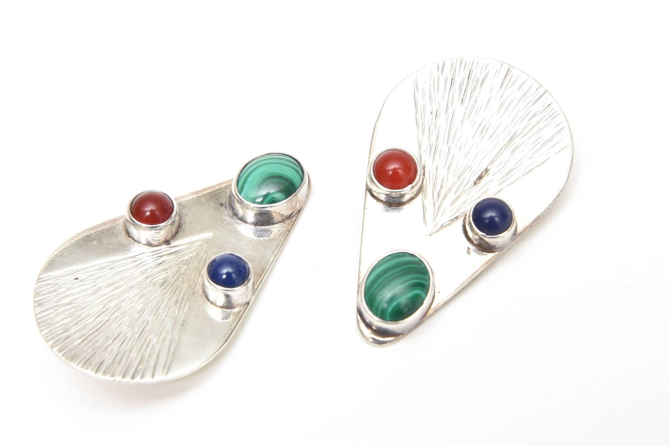 These lovely pair of vintage hallmarked sterling silver clip on earrings have cabochon stones. Malachite, carnelian and blue lace agate are set against the sterling silver. They are Mexican and look lovely on the ear. Hallmarked Care numbered and