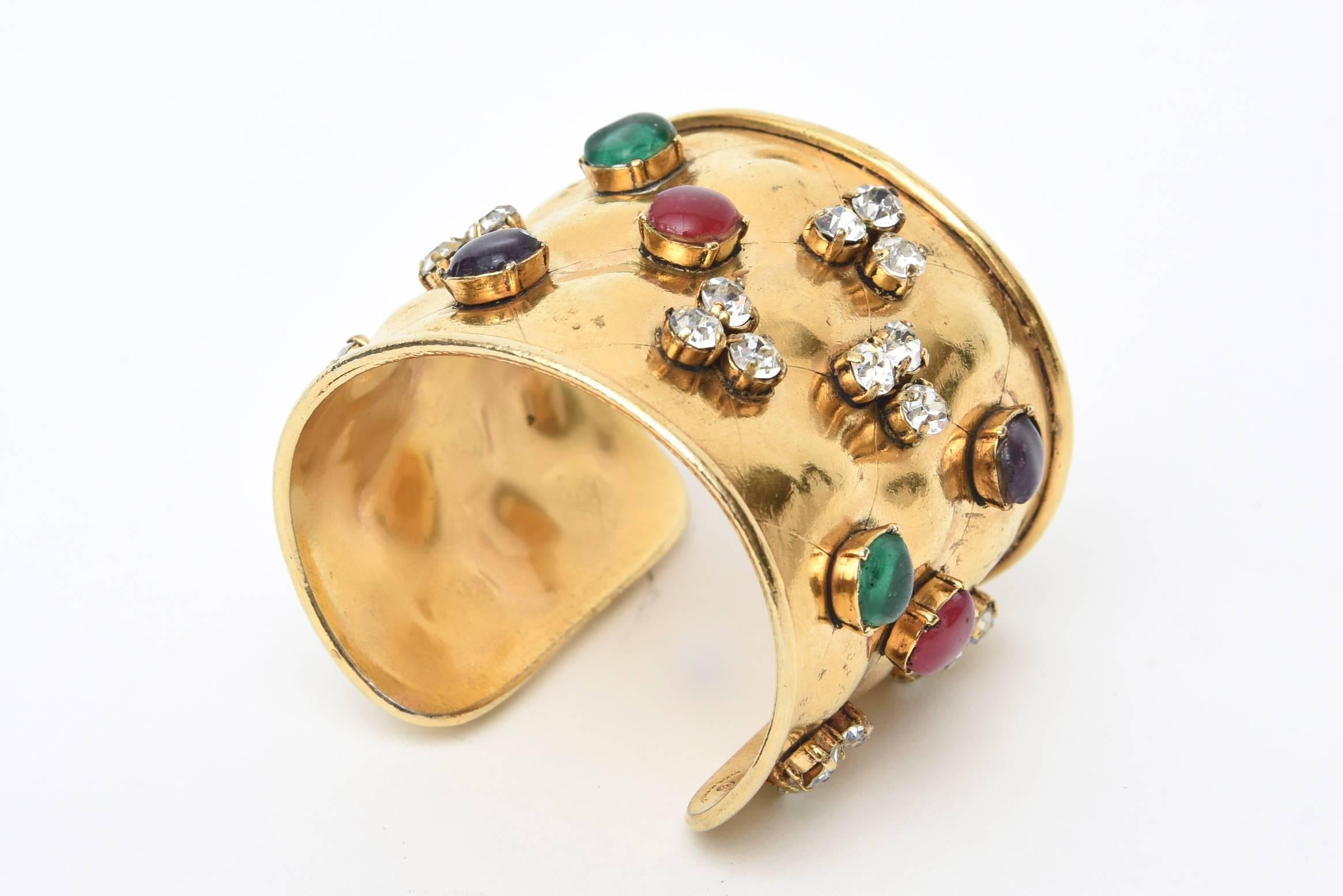 This stunning cuff bracelet by Chanel is signed  channel cc made in france.
It has gorgeous poured glass; which is the gripoux technique and different rhinestones set in cabochon form. On the top, it has a criss cross diamond shaped design in the