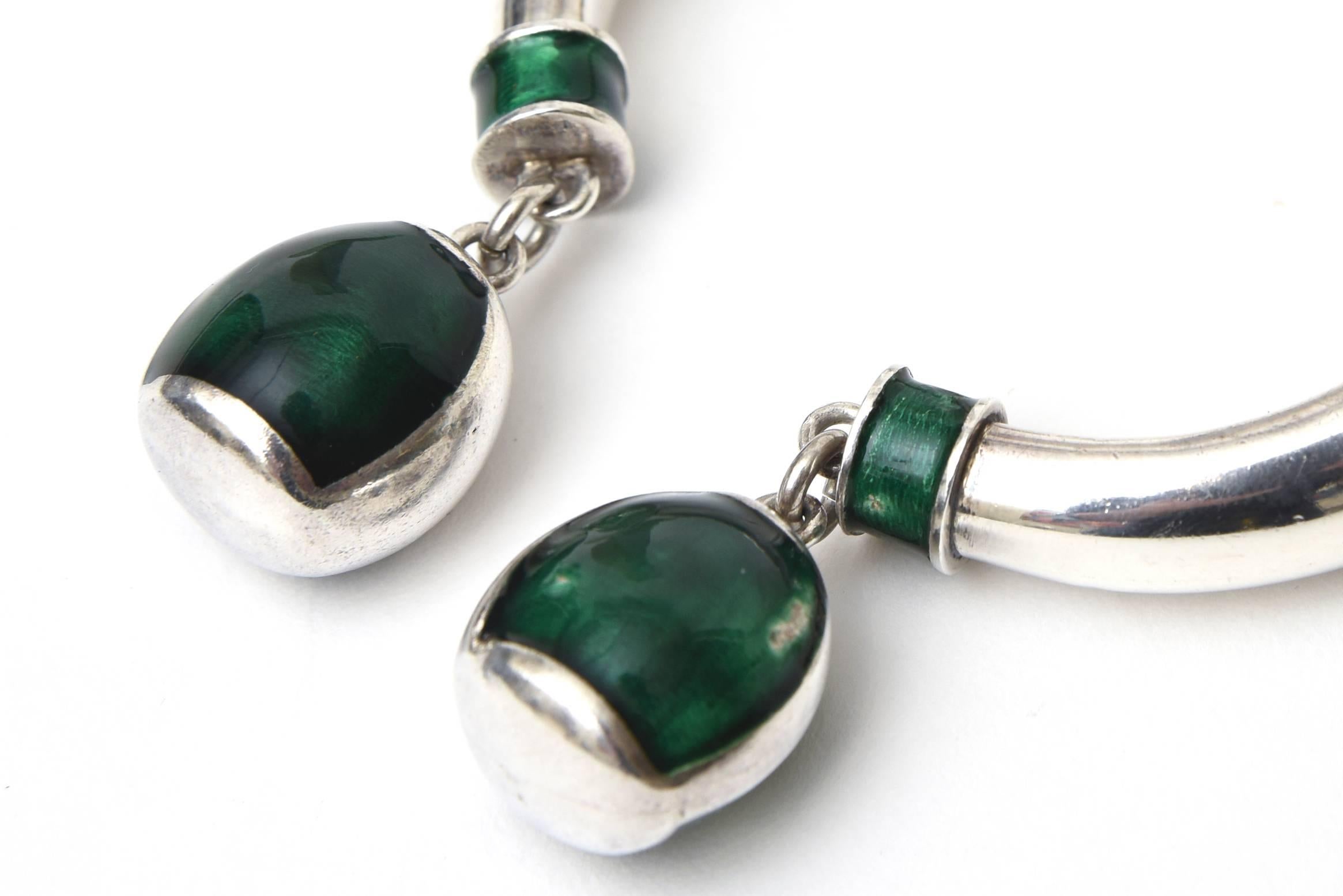 This amazing signed vintage Italian Gucci sterling silver and green malachite enamel bracelet is unusual and rare. It is marked Gucci Italy 925. The hanging pendants add to the sculptural form. There is a hinge to get it on. This will fit a small to
