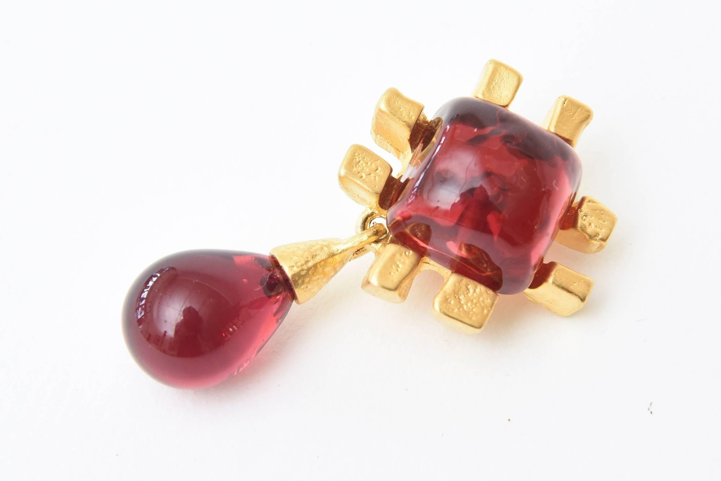 This pair of stunning vintage clip on earrings are by the jewelry artist Andrew Springarn. It is done in the manner of the house of Gripoix. They are poured red glass, modernist in form and sculptural in design. The earrings are one of a kind and