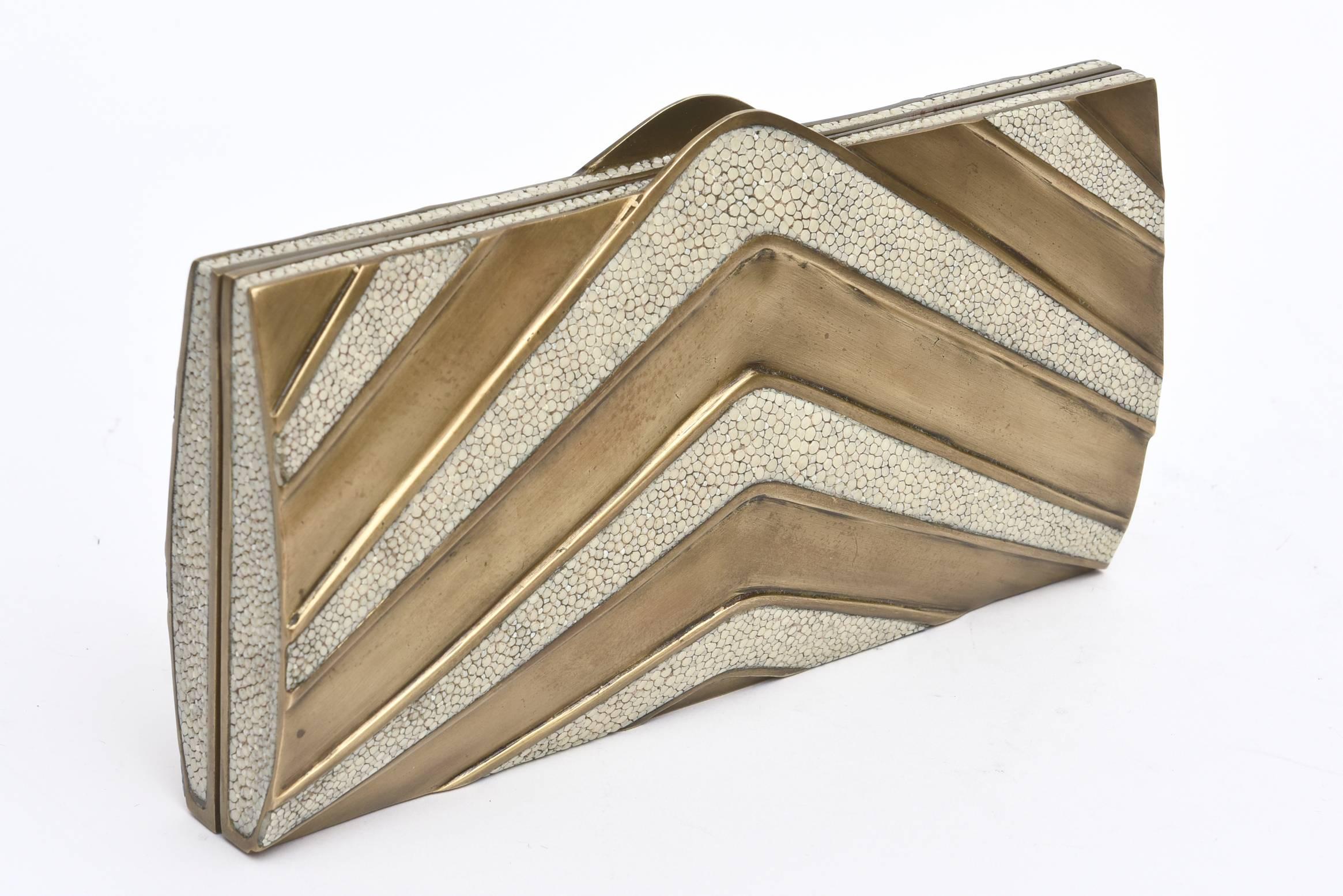 This stunning and almost new R&Y Augousti sculptural clutch is a statement piece. The elements are shagreen and brass. It is has some weight to it.  It holds an I Phone 6 or 6 S. The alternating zig zag pattern between stingray and brass gives it