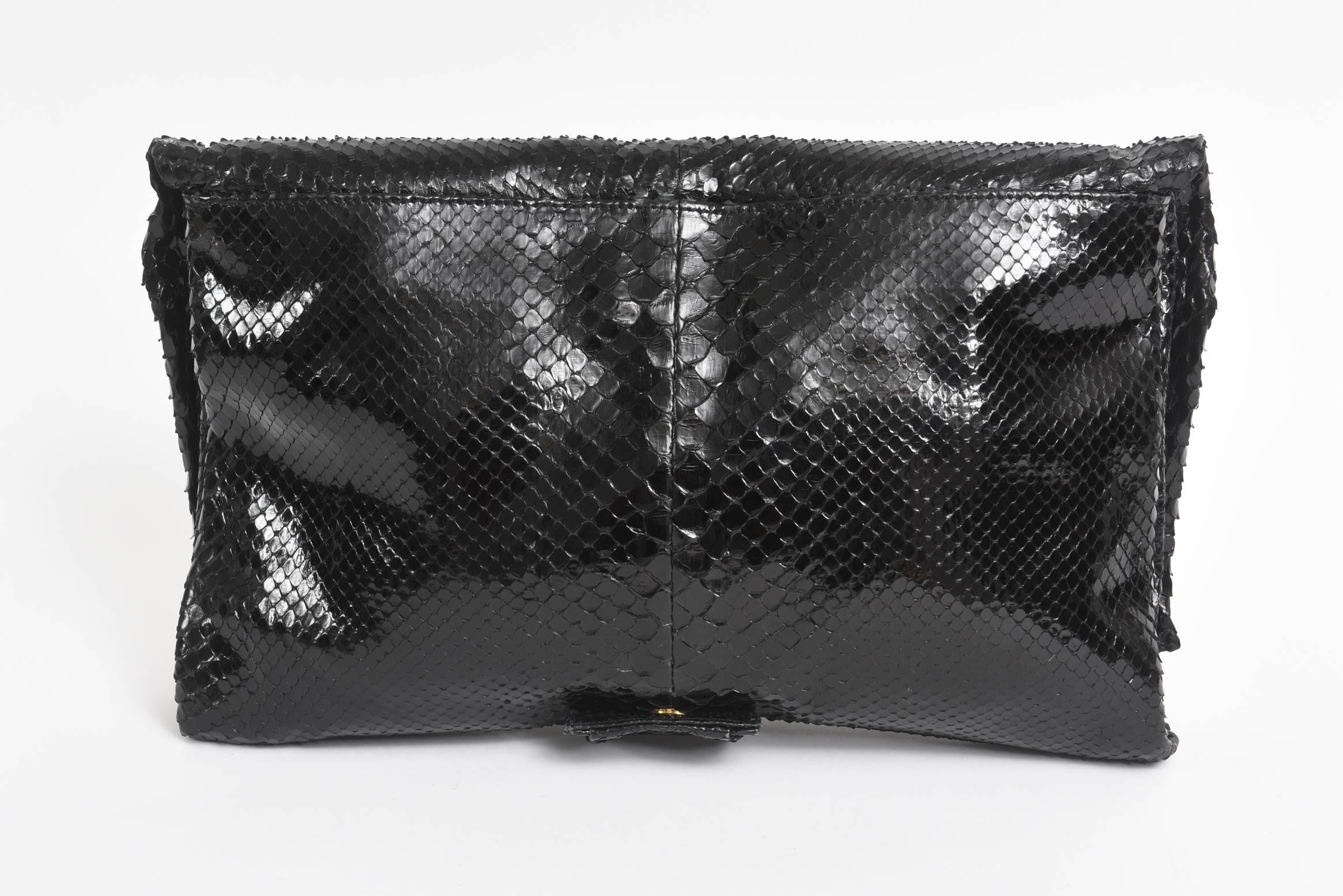 This stunning and rarely used Valentino black python bag / clutch has a removable shoulder strap so becomes two kinds of handbags in one. It has his iconic bow in the center made of black python. The flap over magnetic clasp closes beautifully and