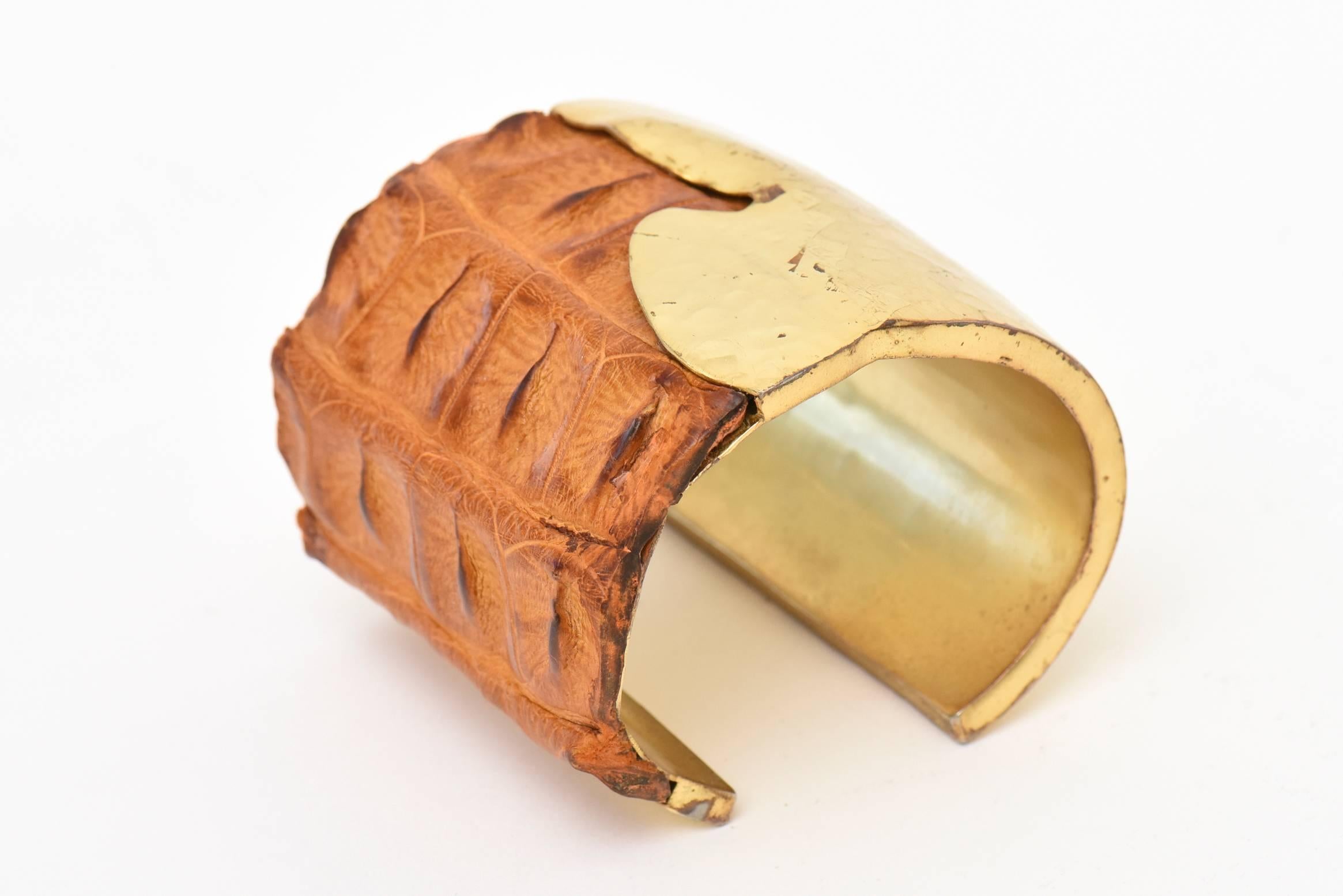 Ce bracelet large en laiton martelé à la main et en cuir de crocodile brun, signé du studio Nada Sawaya New York, est très sculptural. Il est magnifique au poignet. Le bracelet manchette mesure 2,25