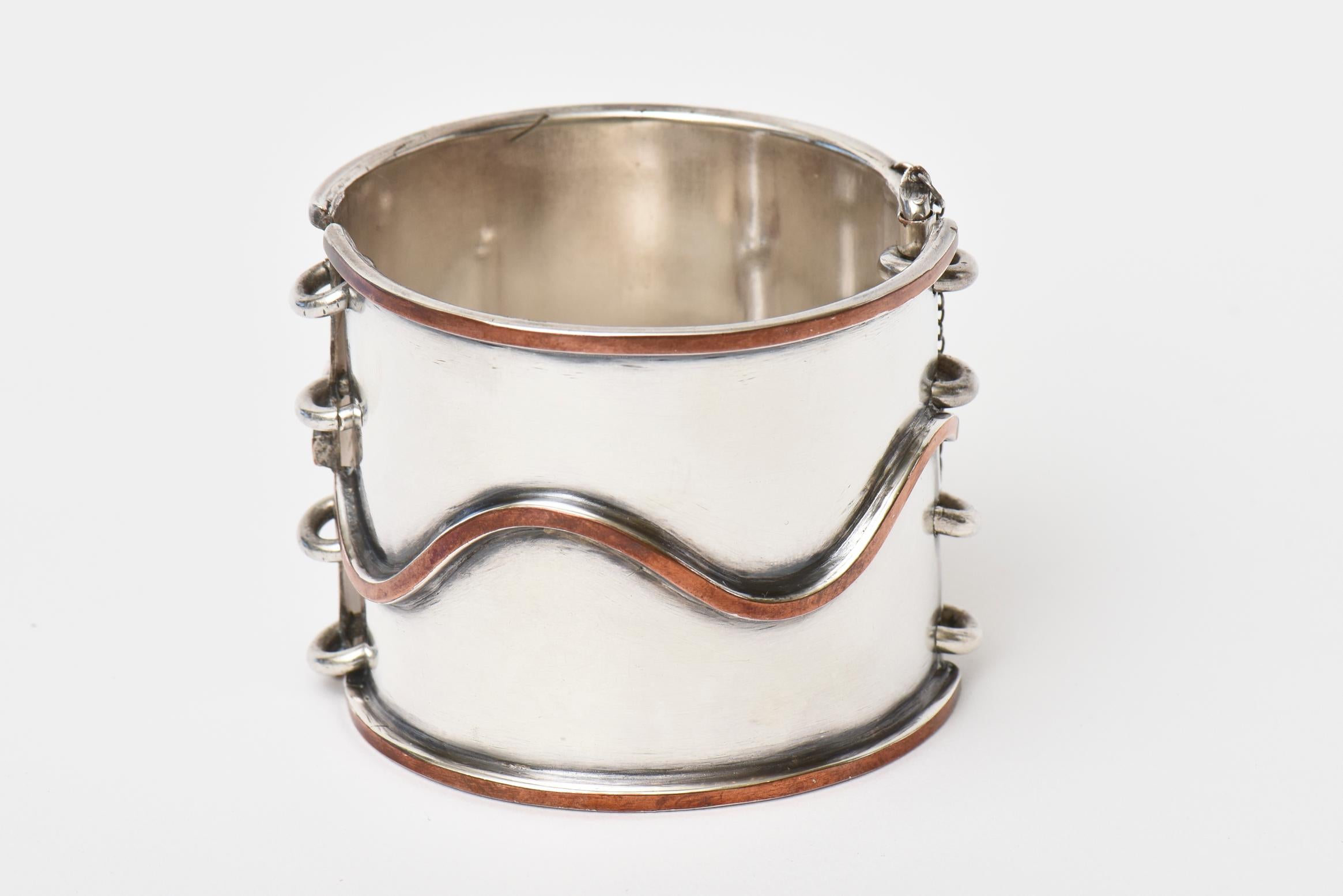 This modernist vintage chrome and copper cuff bracelet has a pin for closing with 4 rings. It is for a small wrist of a size 6 or smaller. This is from the 70's.