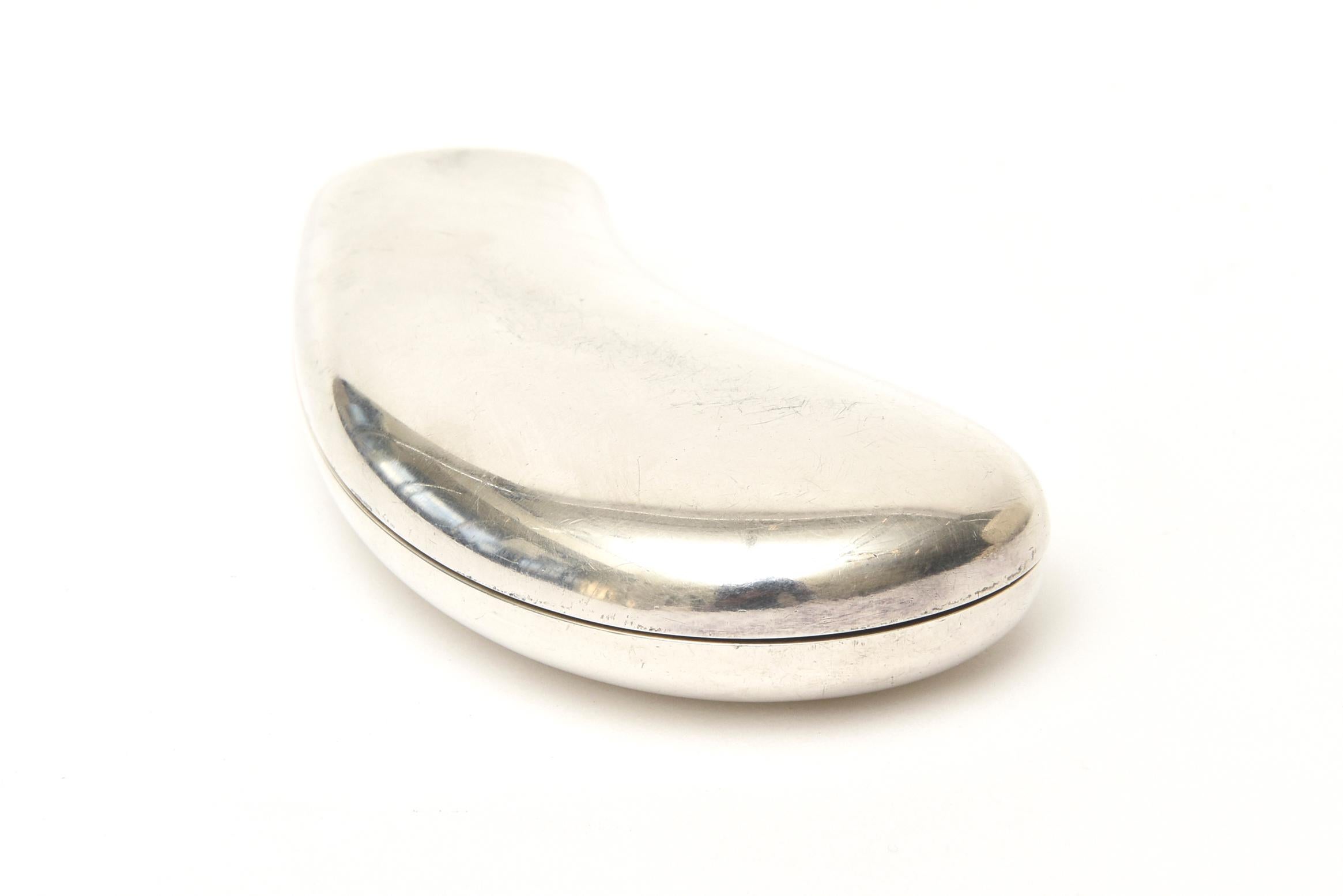 This unbelievable and fabulous signed vintage Italian Gucci sterling silver mirror compact is a piece of organic sculpture in a biomorphic bean form. What a great addition to the necessities of the interior of a chic handbag. It is in resemblance of