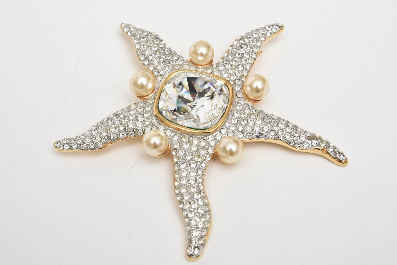 This fabulous vintage runway Valentino marked starfish pin is adorned with 5 faux pearls and multitudes of rhinestones and a crystal center. This is very well made and stellar on. It is from the 70's. This is a stunning pin and could go day or