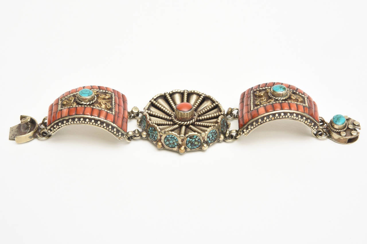 Aztec Indian meets Santa Fe Modern meets old new world in this unusual bracelet that becomes a cuff. 
It is almost Sterling Silver.  Very interesting! and great on the wrist.
It has coral stones, turquoise and silver the tis almost sterling silver.