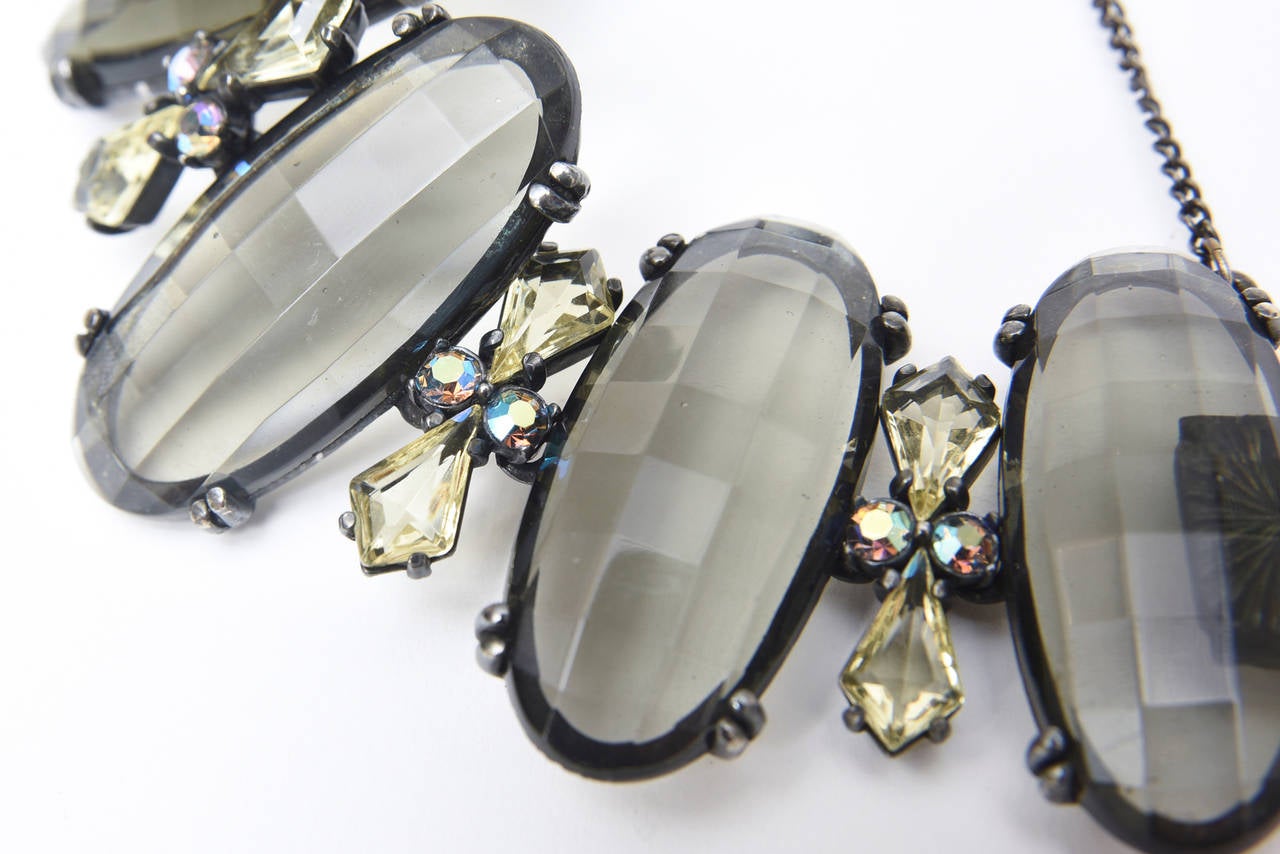This rarely seen and very special signed gorgeous bracket by Elsa Schiaparelli is smoky gray green Austrian faceted crystals that are linked by rhodium plating .In between each large oval crystal are citrine colored crystals with round aurora