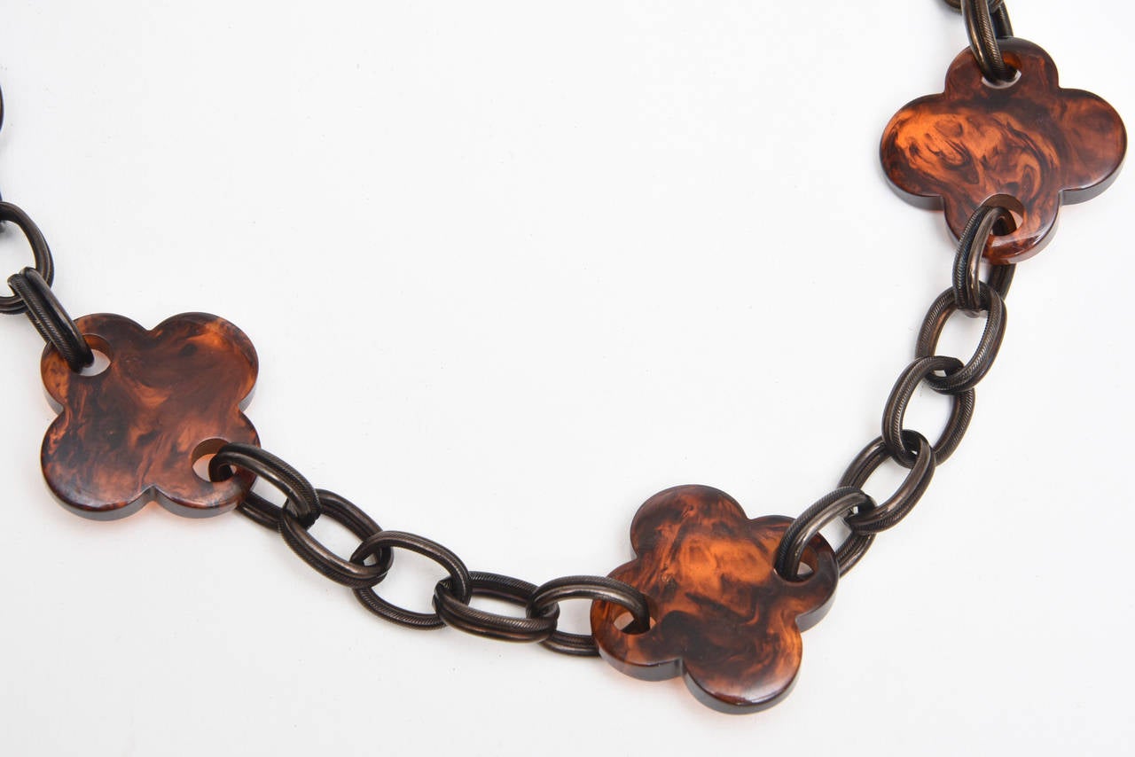 The four leaf clover design of the resin tortoise necklace is a beautiful contrast to the blackened metal of the chains/links. This is so timeless and perfect for fall coming..
It has a metal tag that says Yves Saint Laurent.
Ultra chic and au so