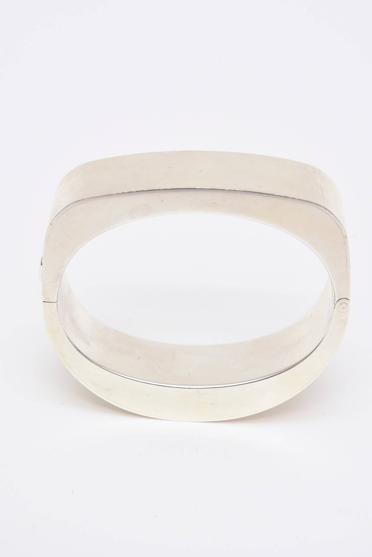 This modernist hallmarked sculptural sterling silver cuff bracelet hugs the wrist beautifully. There are hallmarks of the silver and other markings and the hinge closure fits well. It will fit ONLY a small wrist of 6